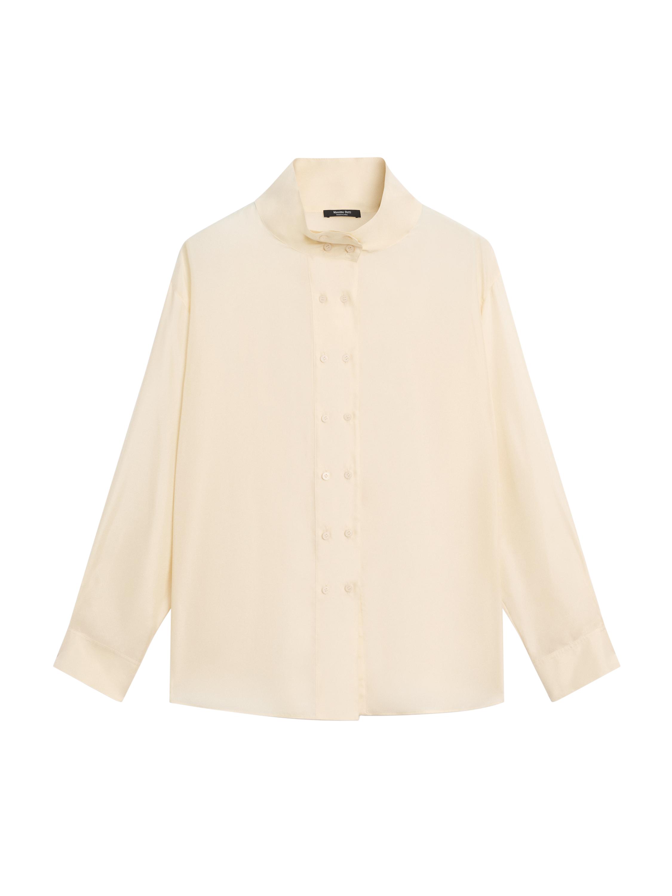 Вид спереди на ванильную рубашку с высоким воротником и центральной застежкой на пуговицах. Длинные рукава и прямой крой.