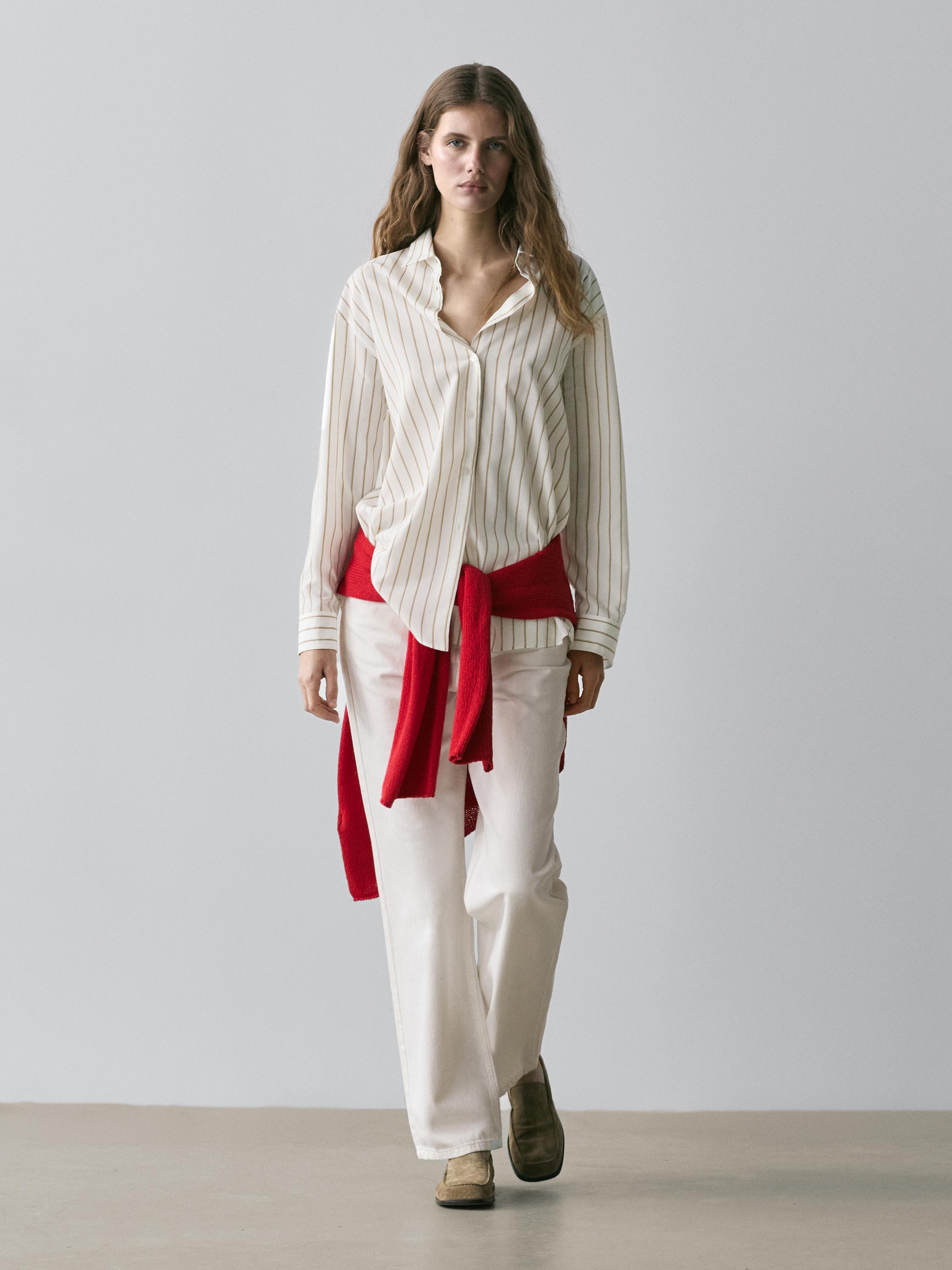 Outfit with a white tricolor striped shirt, white pants, and a red sweater tied at the waist.