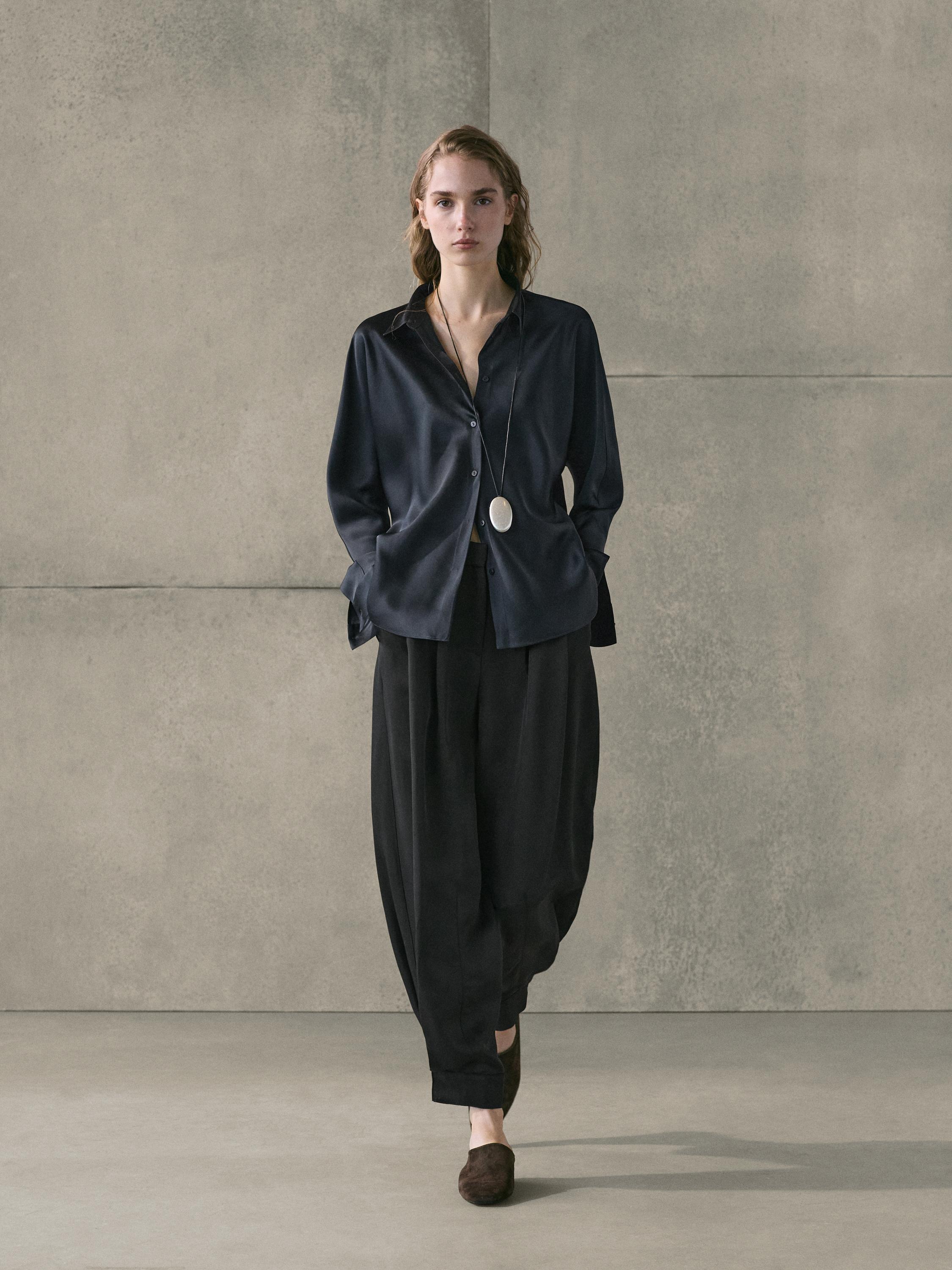 Dark blue satin button-down shirt and wide-leg black pants set.