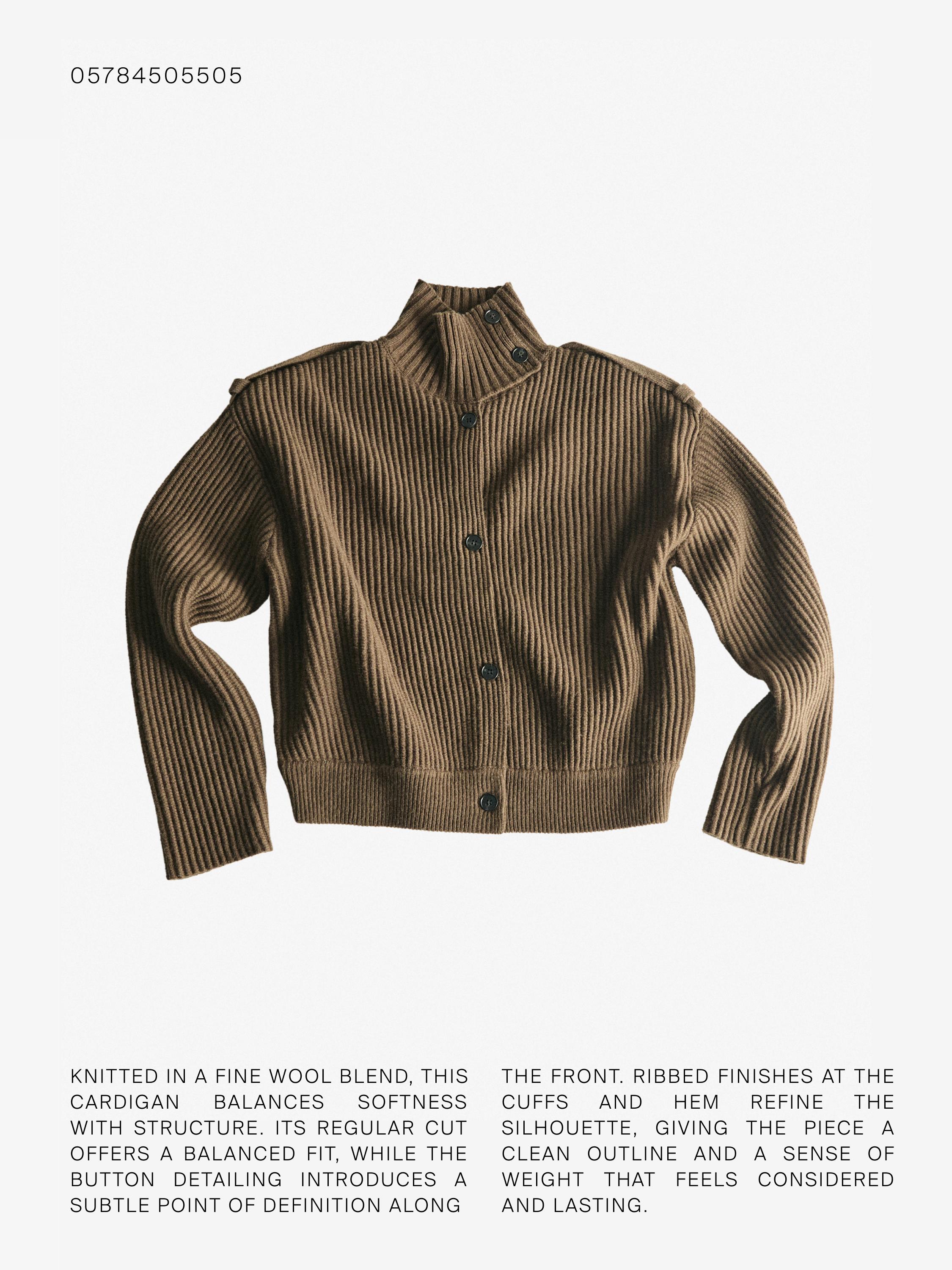 Vista frontal de cárdigan caqui de punto con cuello alto, botonadura central y mangas largas. Detalle de botones en el cuello.