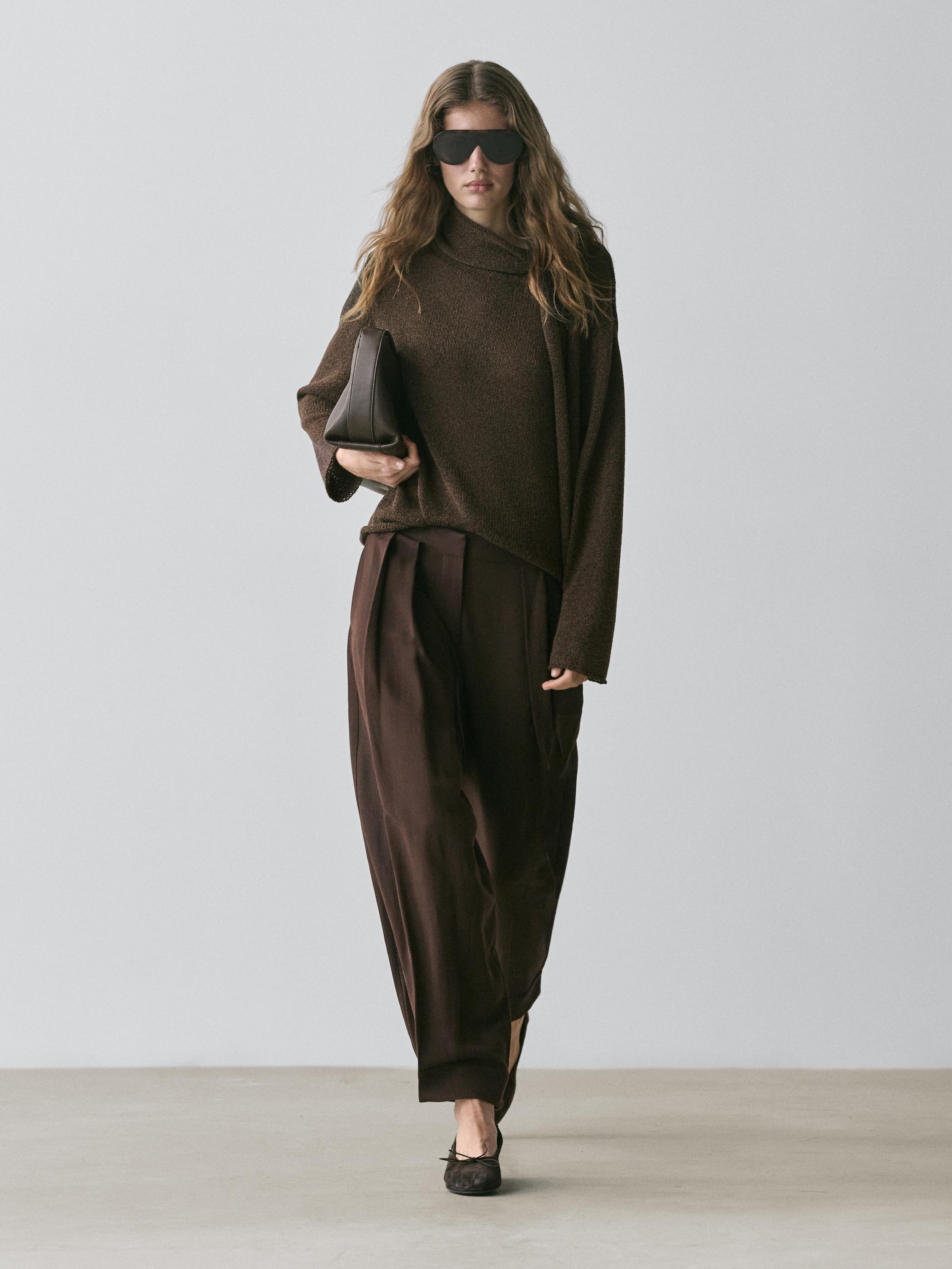 Brown turtleneck sweater and brown baggy pants set with button detail.