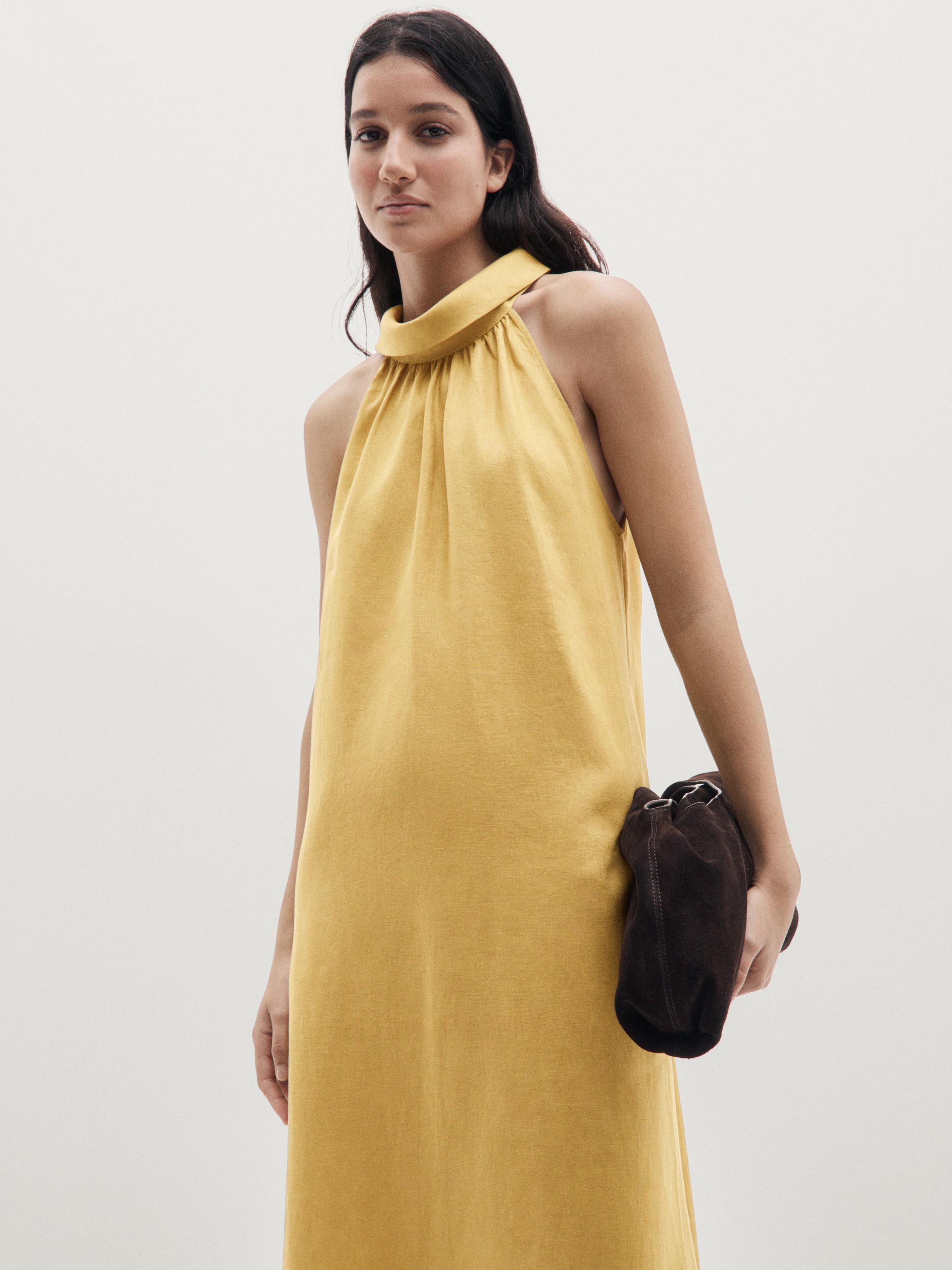 Plano medio de vestido largo pistache con cuello halter.