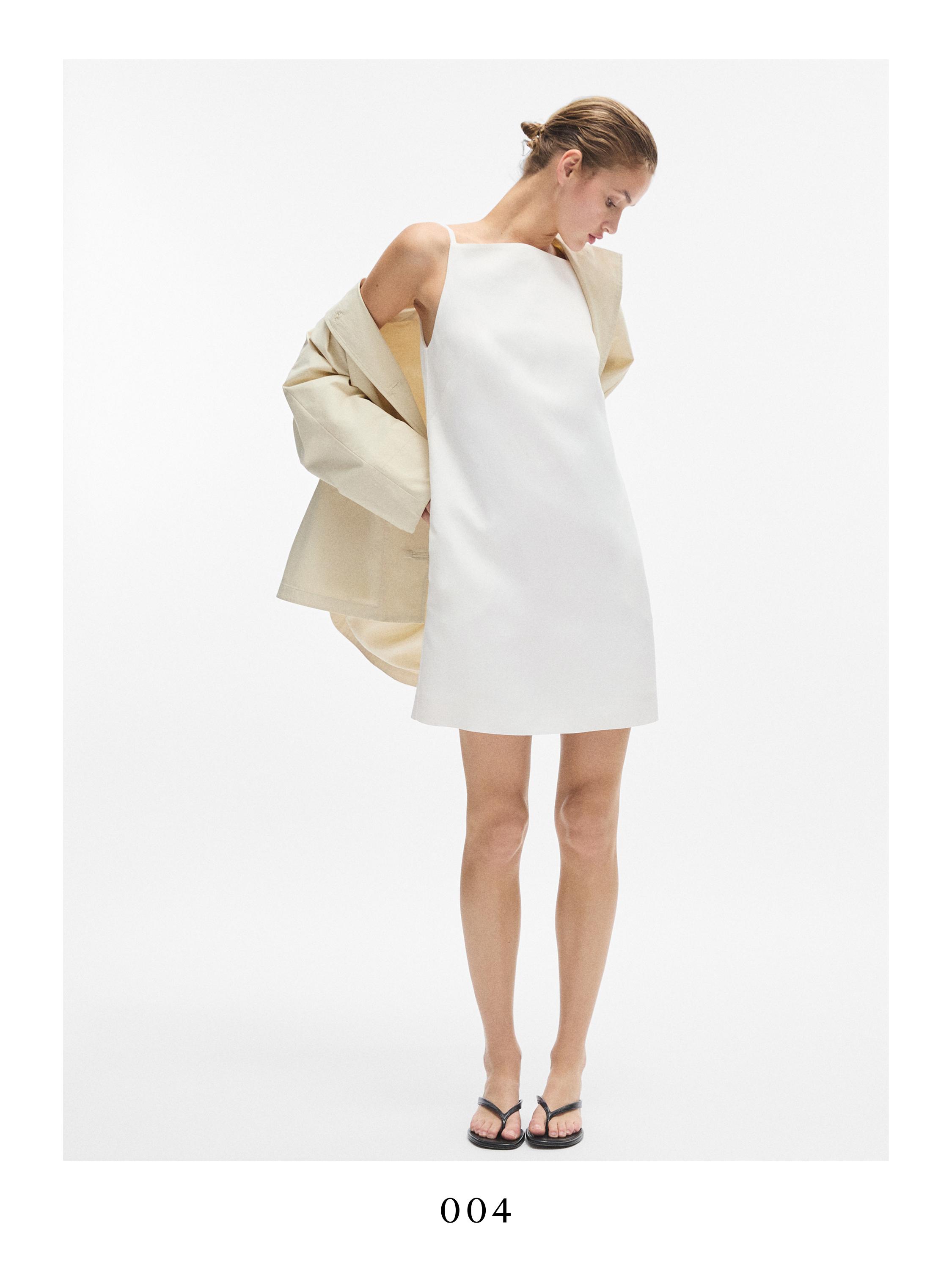 Σετ λευκό μίνι φόρεμα χωρίς μανίκια και μπεζ σακάκι στους ώμους.