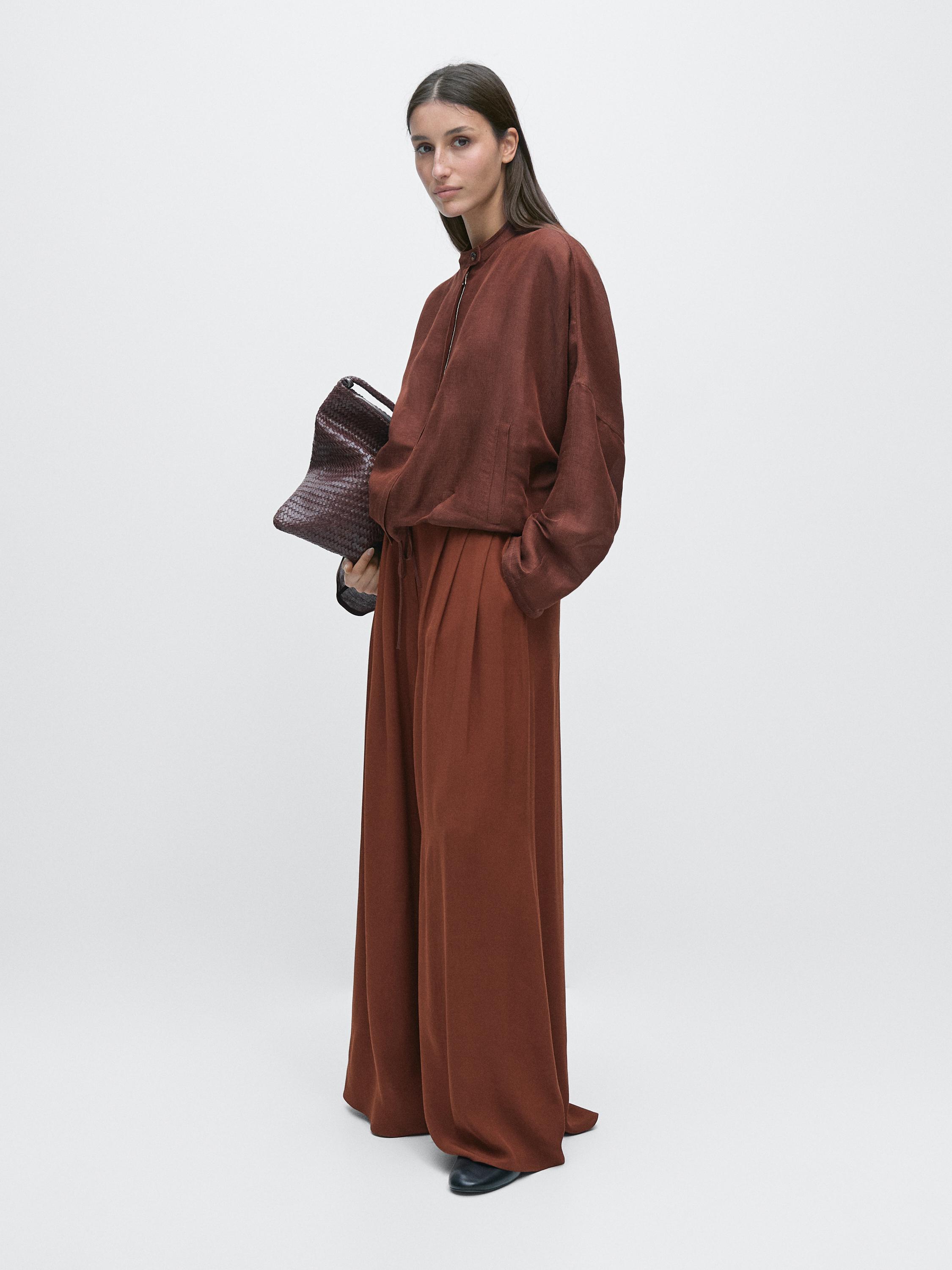 Orange zip-up blouse and matching wide-leg pants set, with visible side pockets.