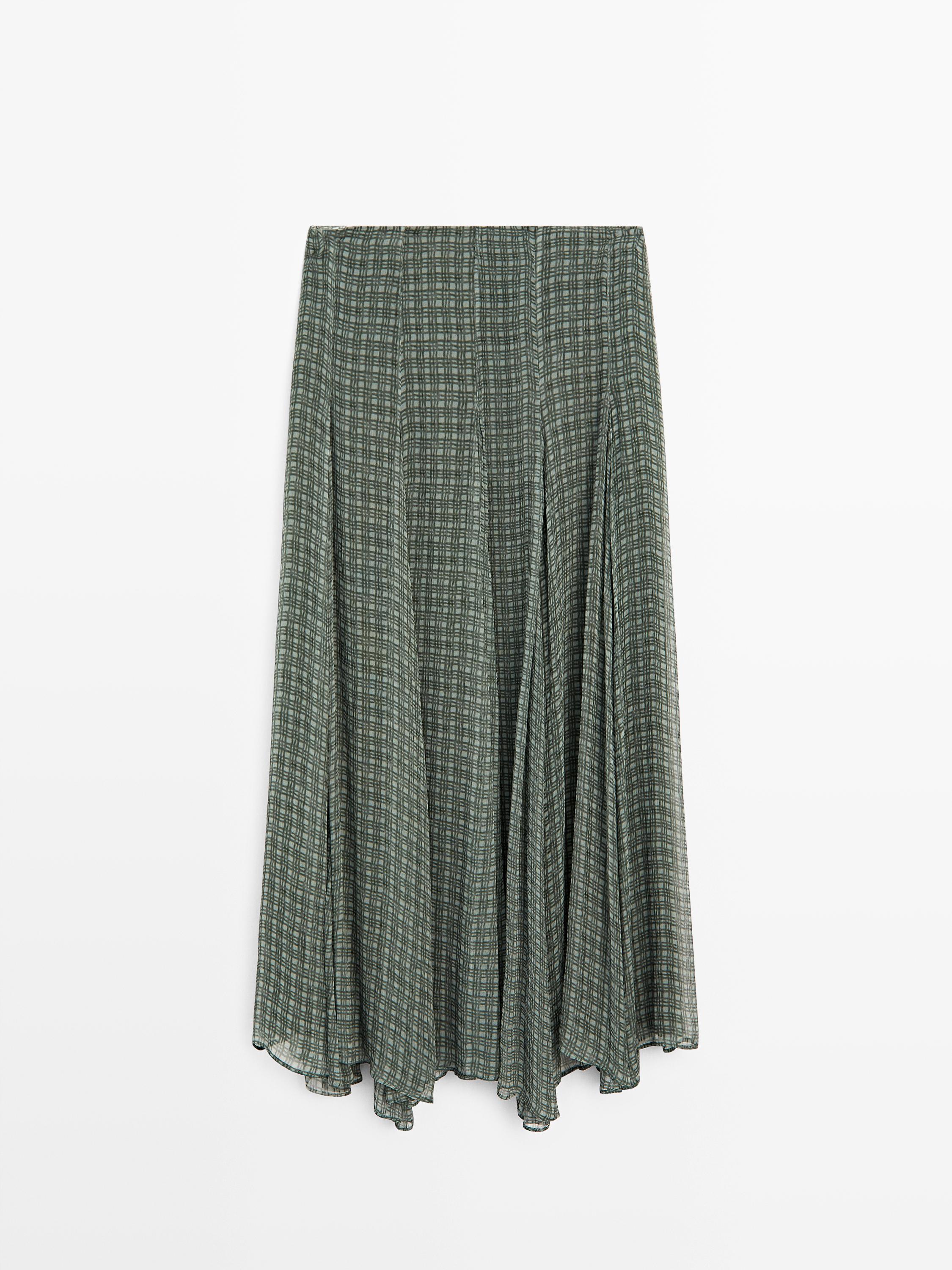 Vista frontal de falda midi verde fluida con estampado de cuadros y diseño godet.