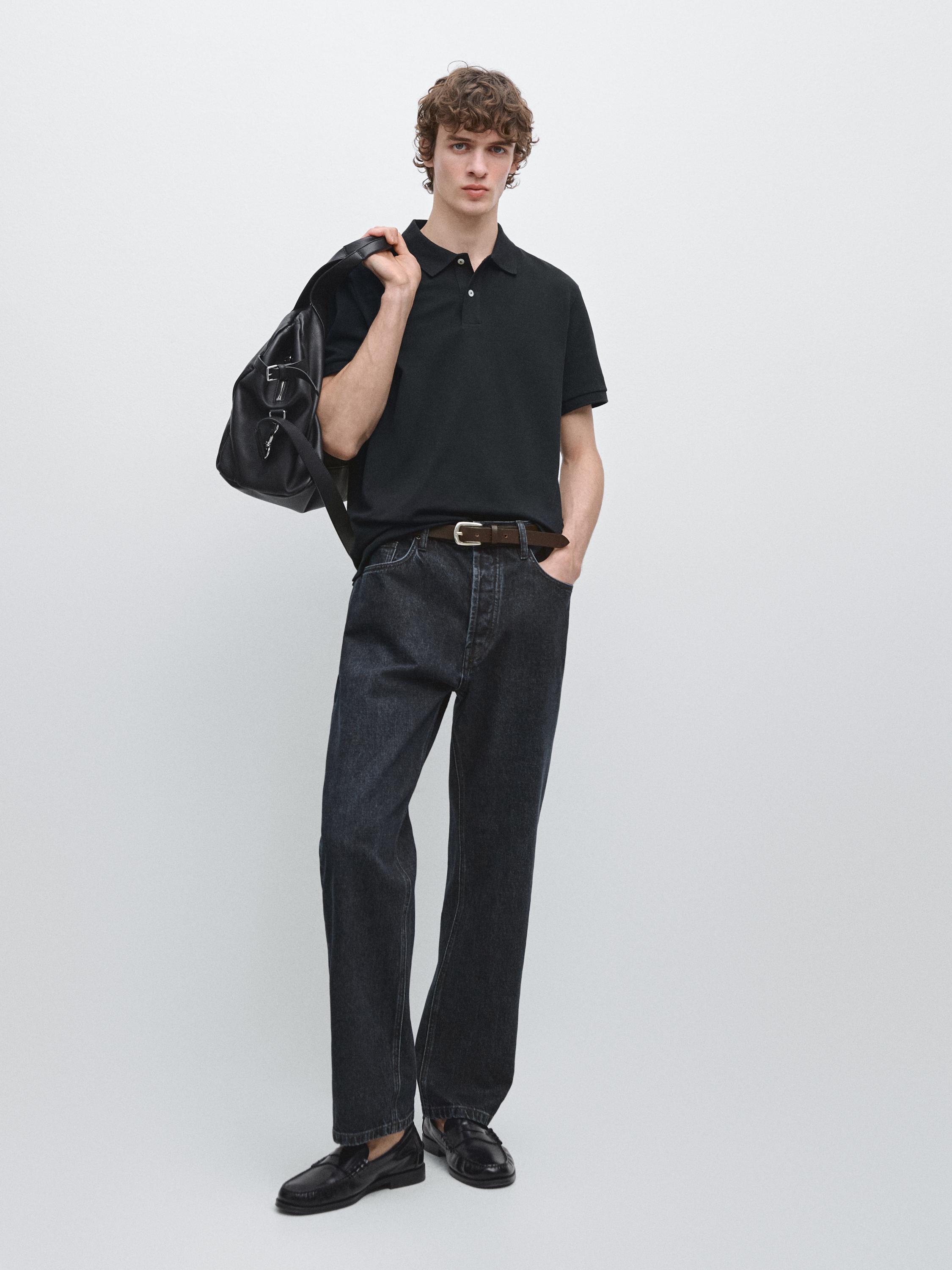 Conjunto de polo azul marino de manga corta y pantalones vaqueros oscuros con cinturón marrón.