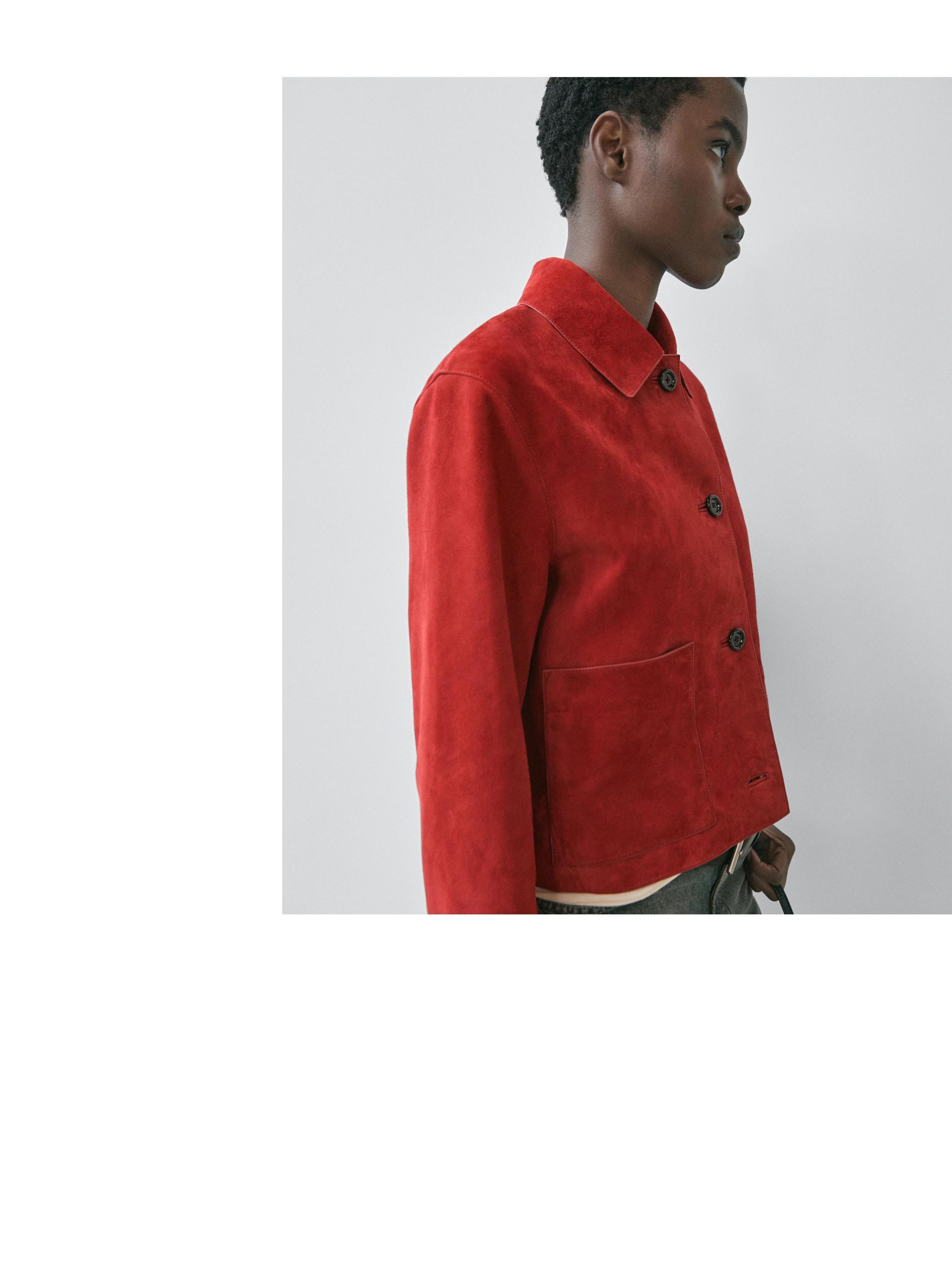 "Medium shot of a short red jacket with dark buttons and a visible side pocket."
