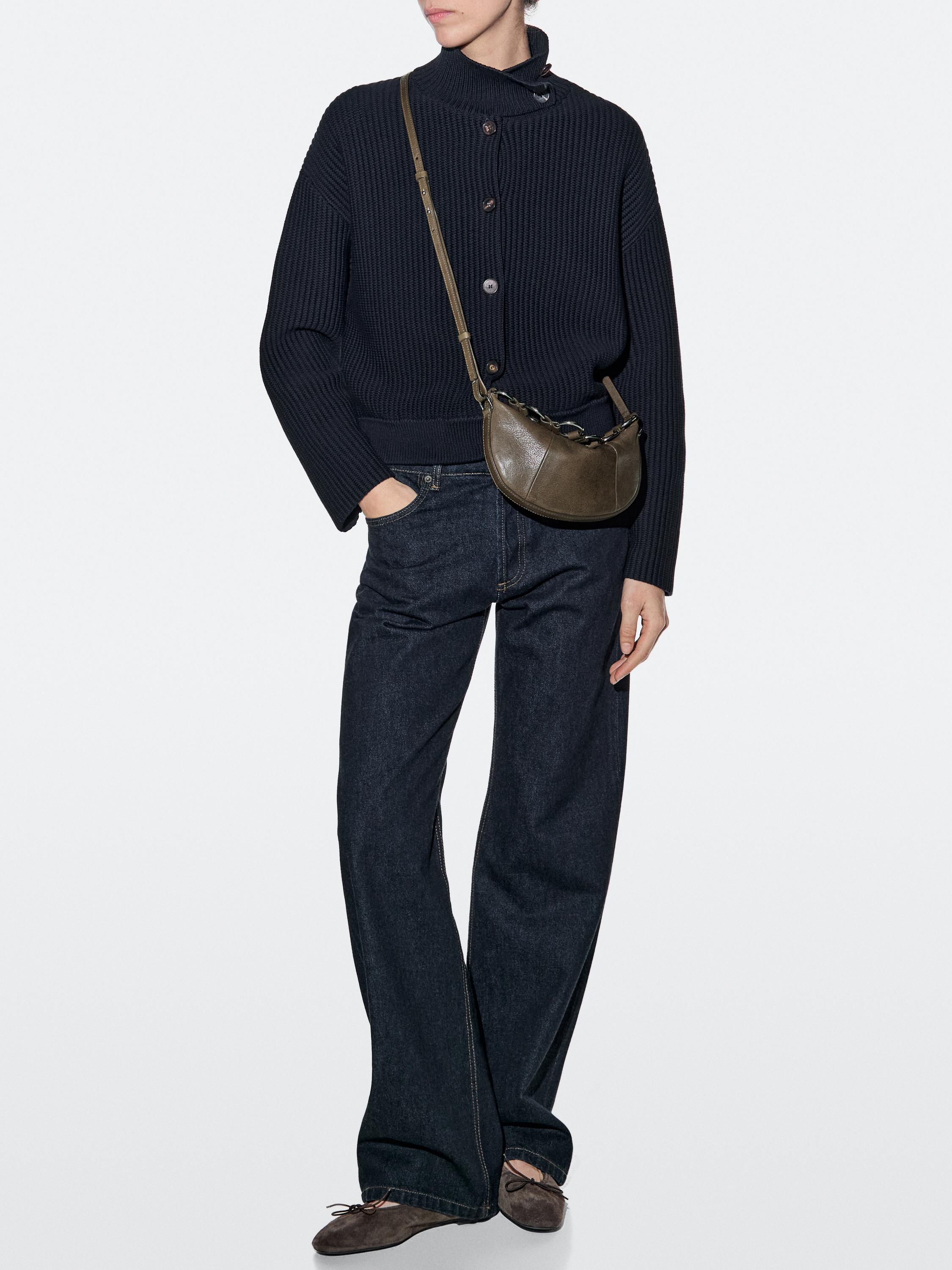 Navy button-up sweater set, dark jeans, and khaki crossbody bag.