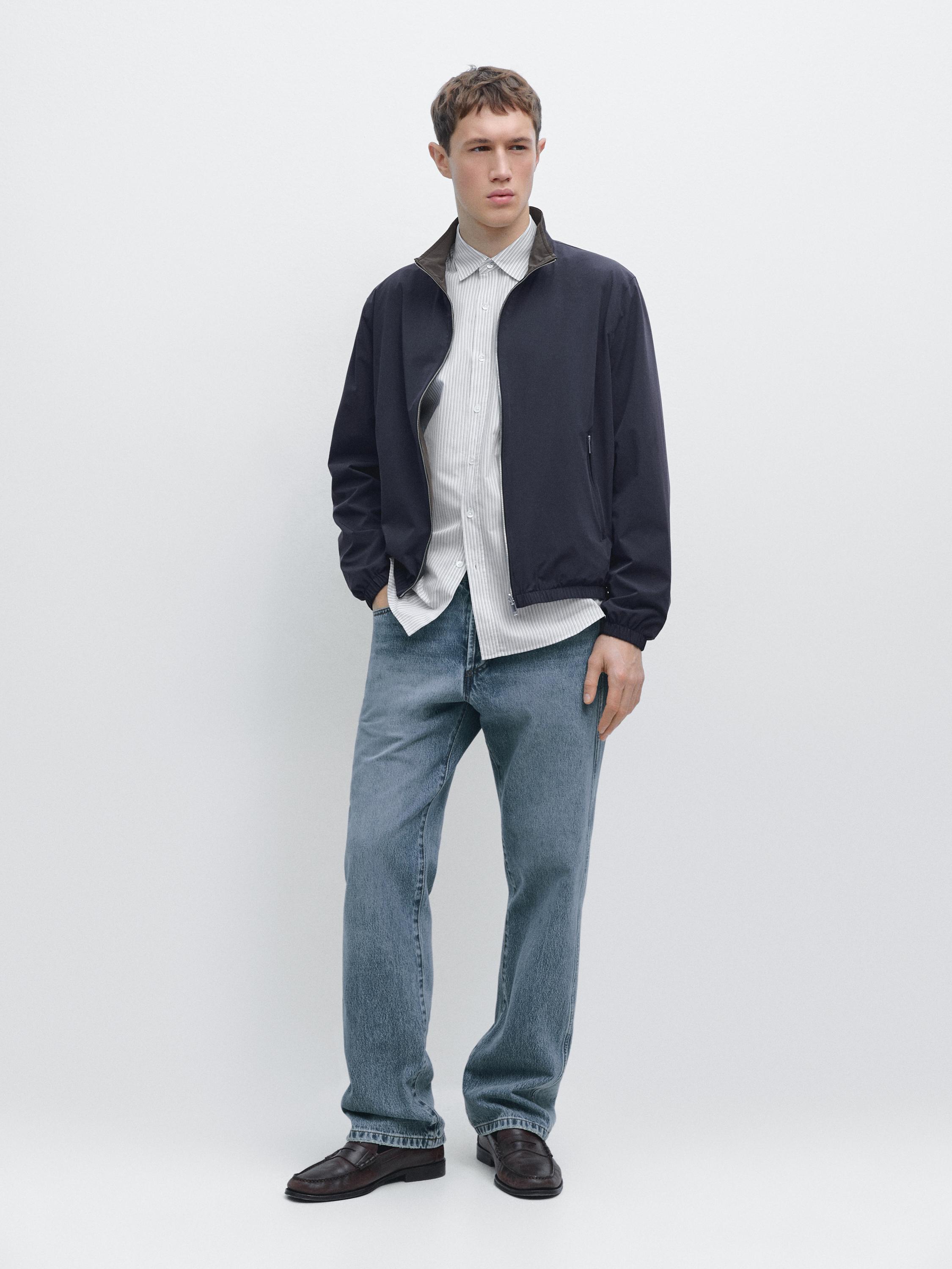 Navy blue zip-up jacket set, white striped shirt, blue jeans, and brown shoes.