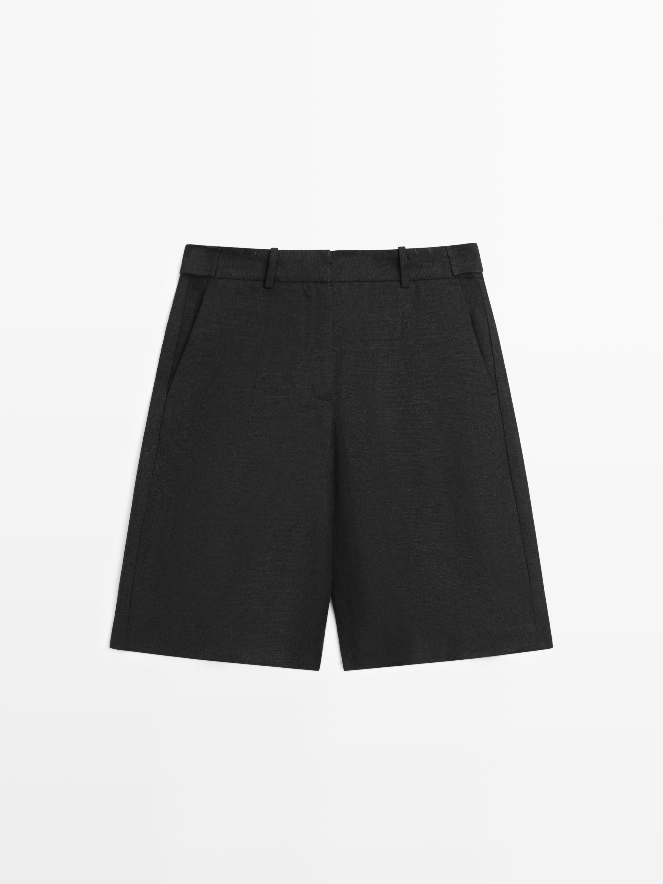 Vista frontal de bermuda negra larga con bolsillos laterales y trabillas para cinturón.