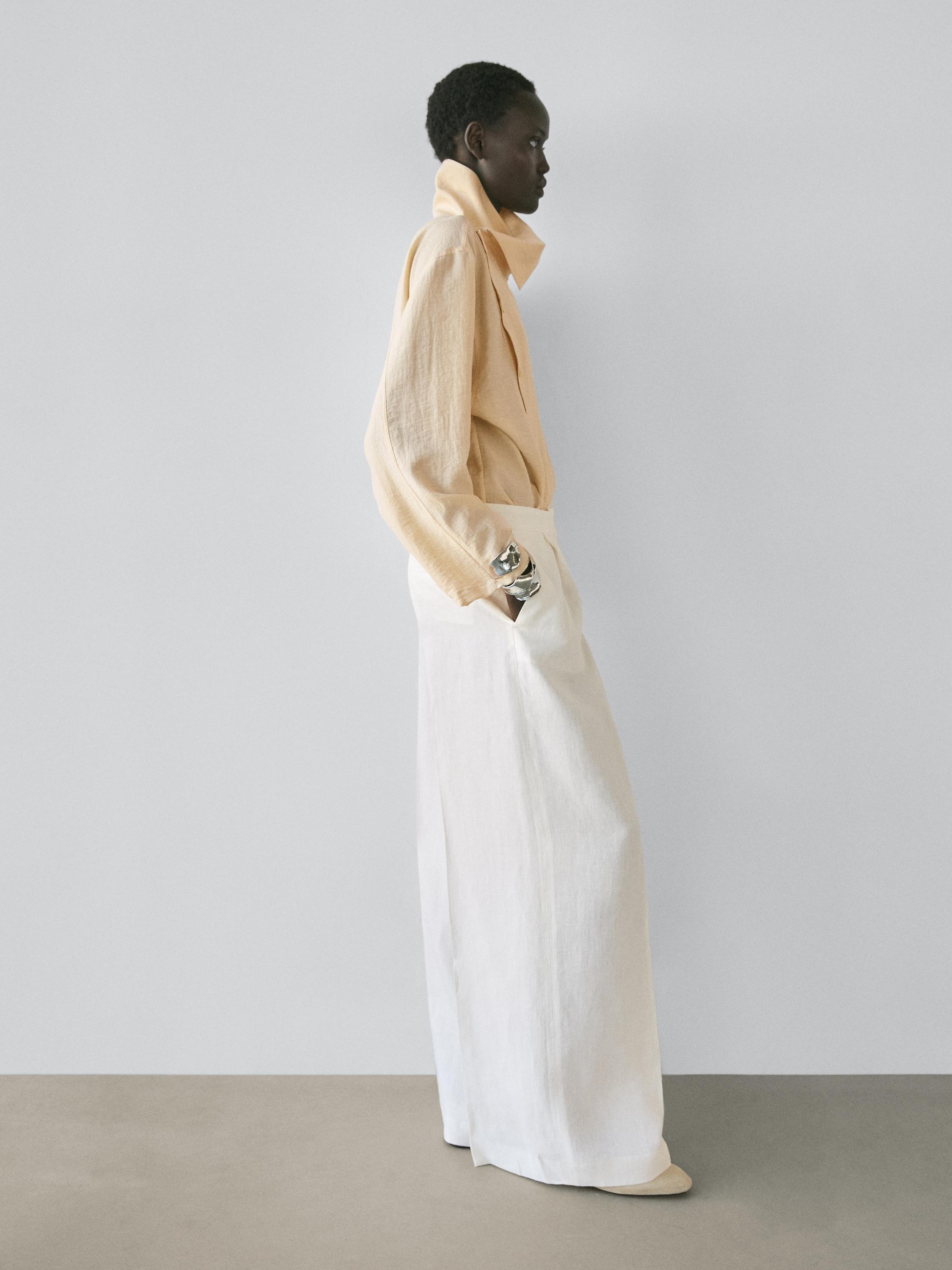 ชุดเสื้อคอเต่าสีเบจและกางเกงขายาวทรงขากว้างสีขาวงาช้าง