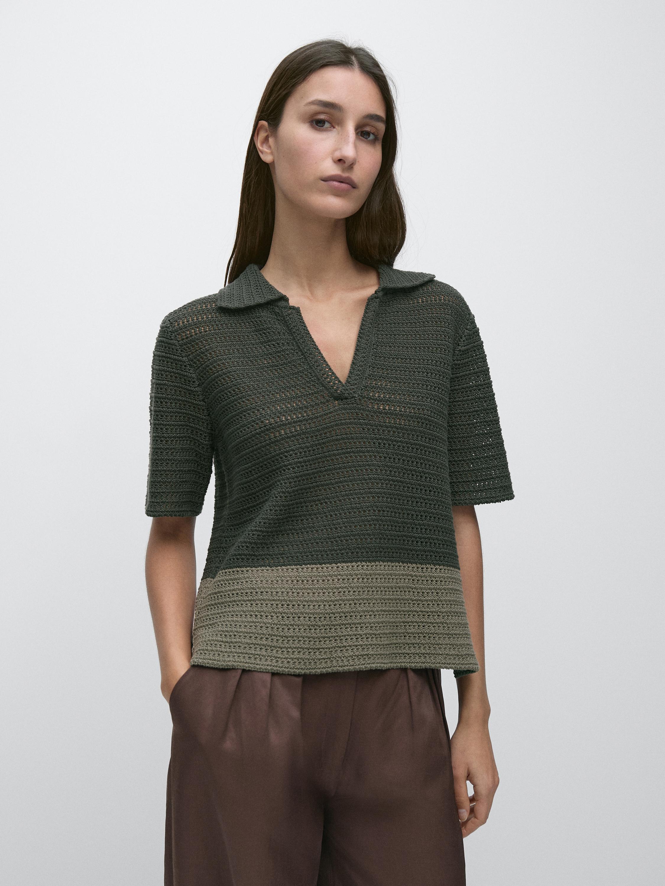 Mid-shot of a green openwork knit polo shirt, short-sleeved, with a collar and bottom hem in a lighter shade.