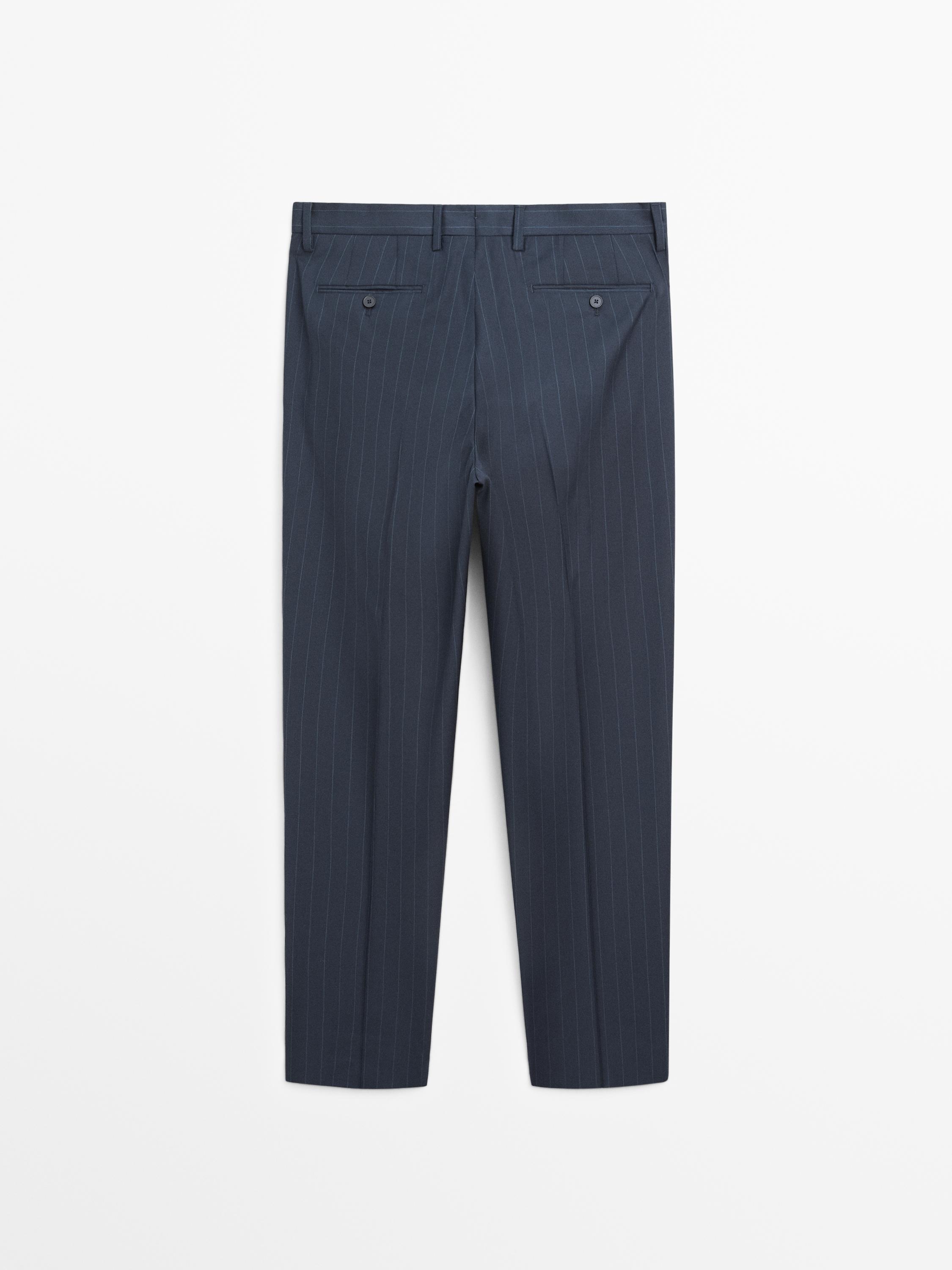 Rear view of navy blue dress pants with pinstripes and buttoned back pockets.