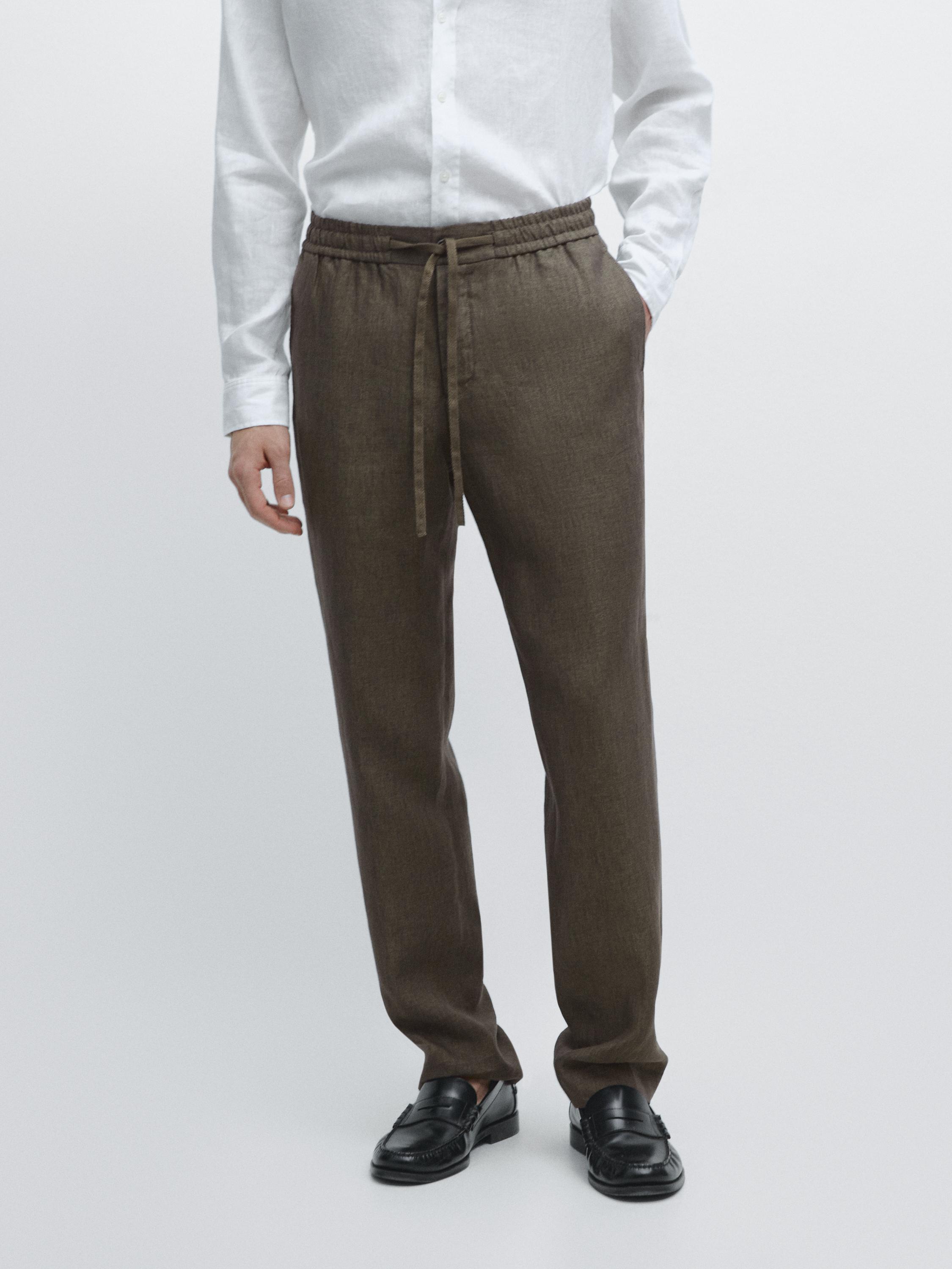 Green jogger pant set with elastic waist and adjustable drawstring, side pockets, white shirt.