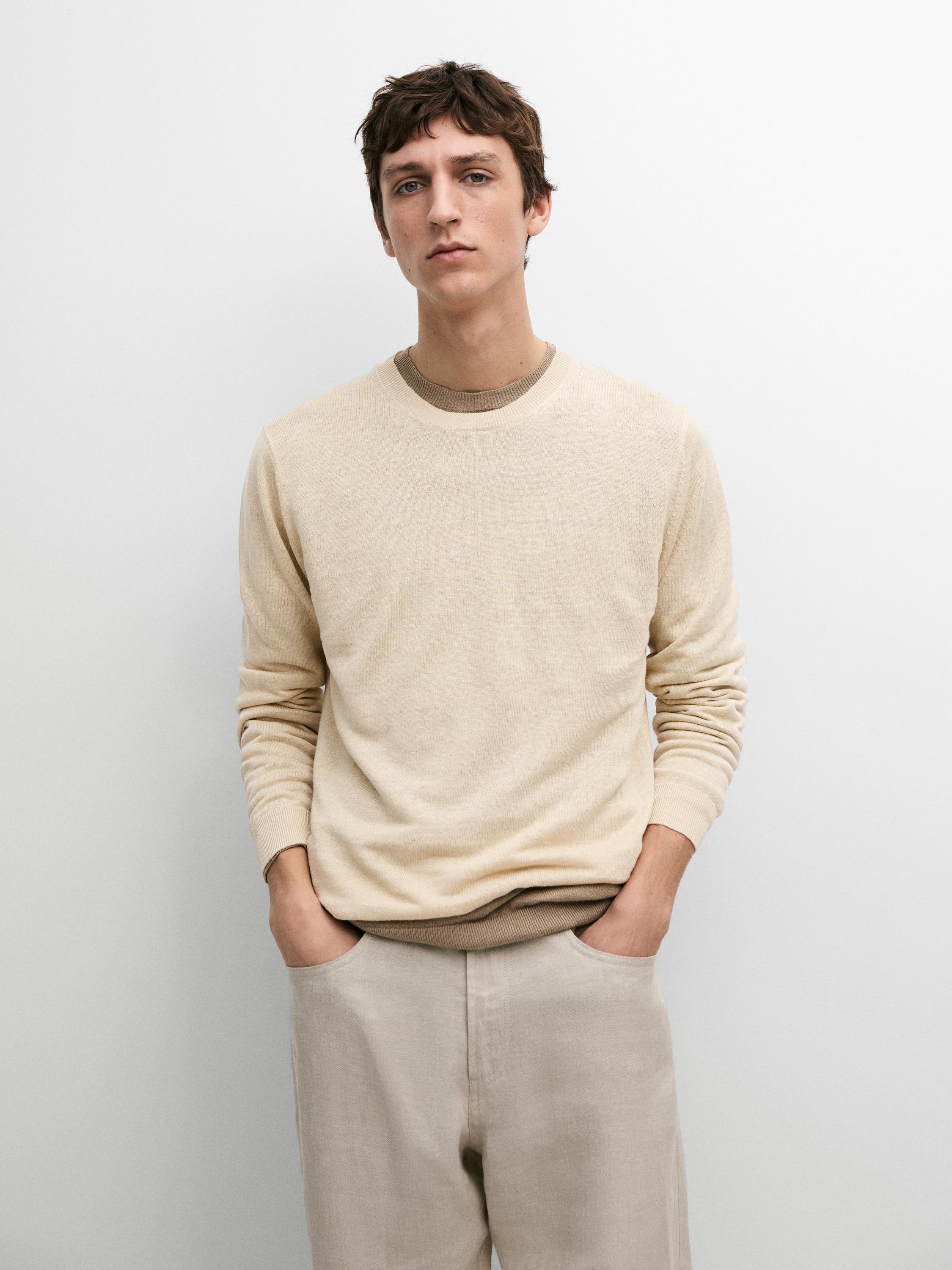 Puntuzko jertse banilla multzoa, lepo biribilekoa, eta praka beixak, alboetan poltsikoak dituela.