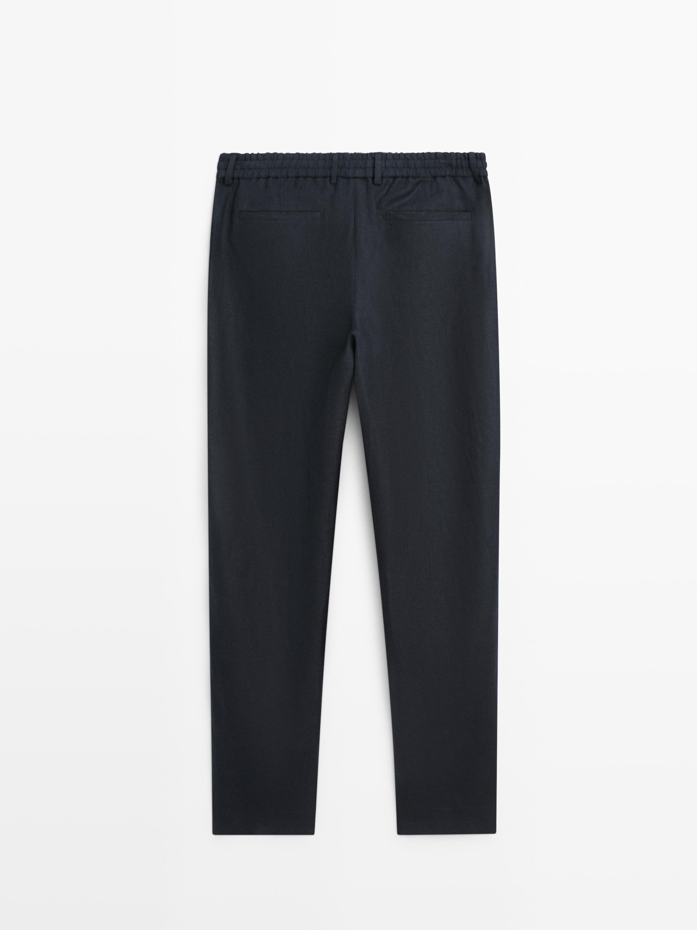 Rückansicht einer tiefblauen Hose mit elastischem Bund und Gesäßtaschen.