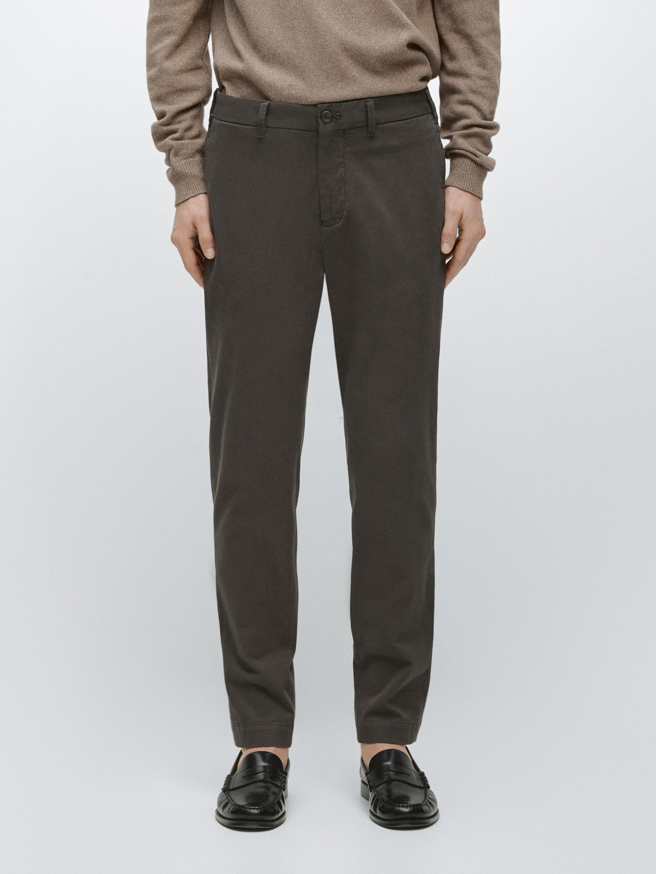 Brown slim-fit pants set with side pockets and button closure, combined with a beige sweater.