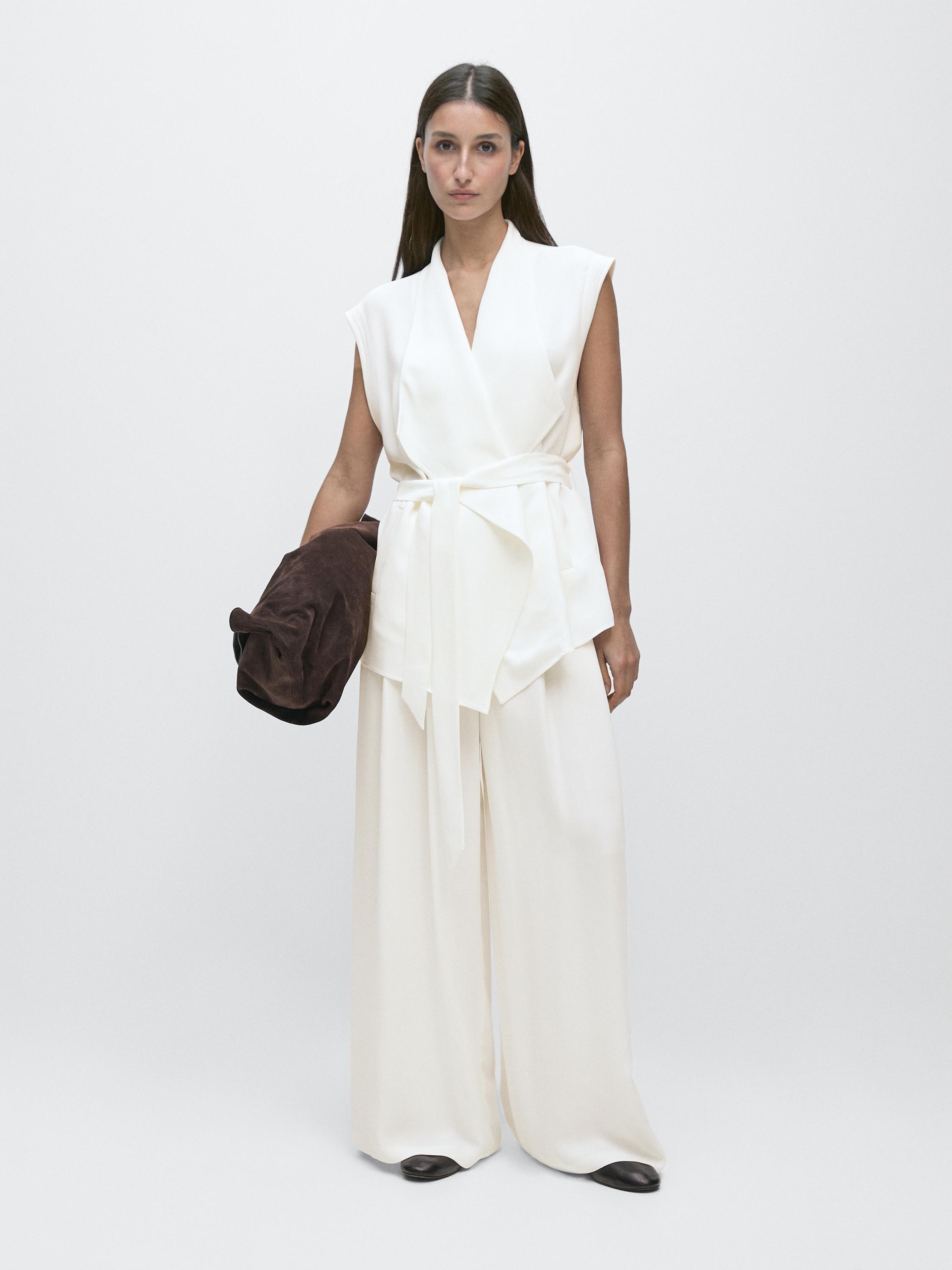 Set rompi tanpa lengan putih tulang dengan ikat pinggang dan celana lebar yang serasi.