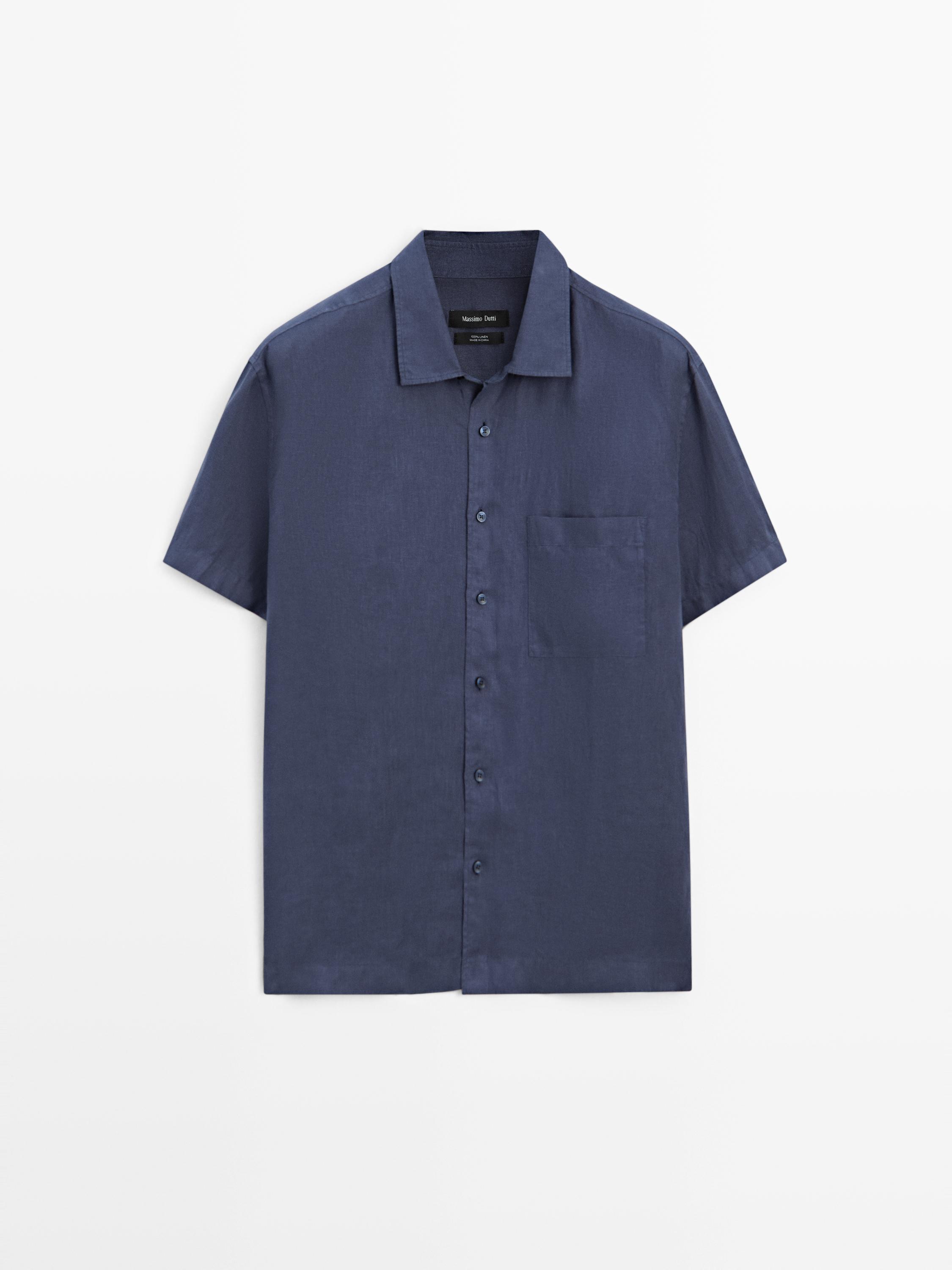 منظر أمامي لقميص أزرق داكن بأكمام قصيرة وياقة كلاسيكية، أزرار أمامية وجيب على الصدر.