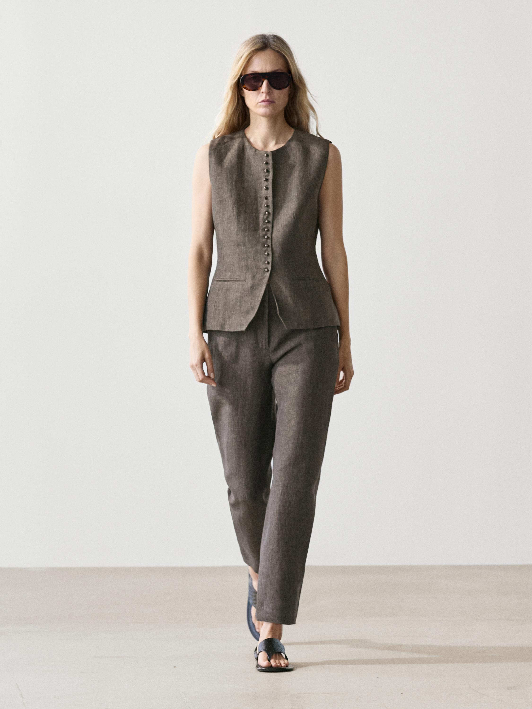 Conjunto de chaleco marrón sin mangas con botonadura frontal y pantalones a juego rectos.