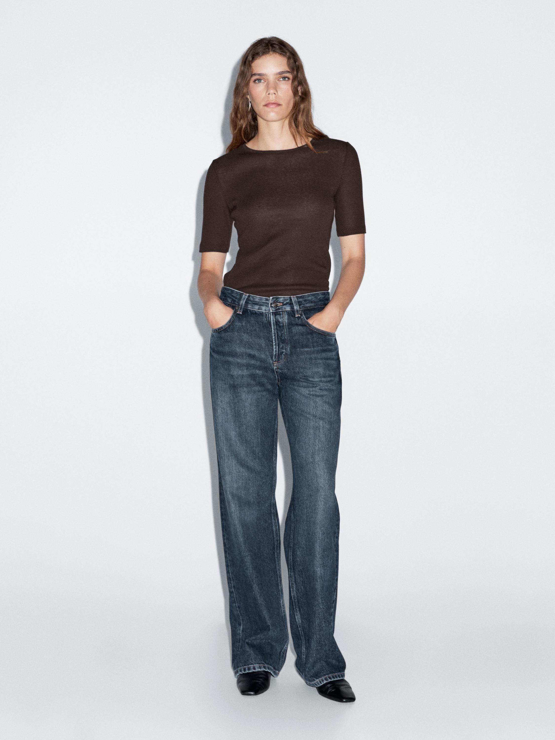 Conjunto de camiseta marrón de manga corta y jeans azul oscuro de pierna ancha con bolsillos laterales.