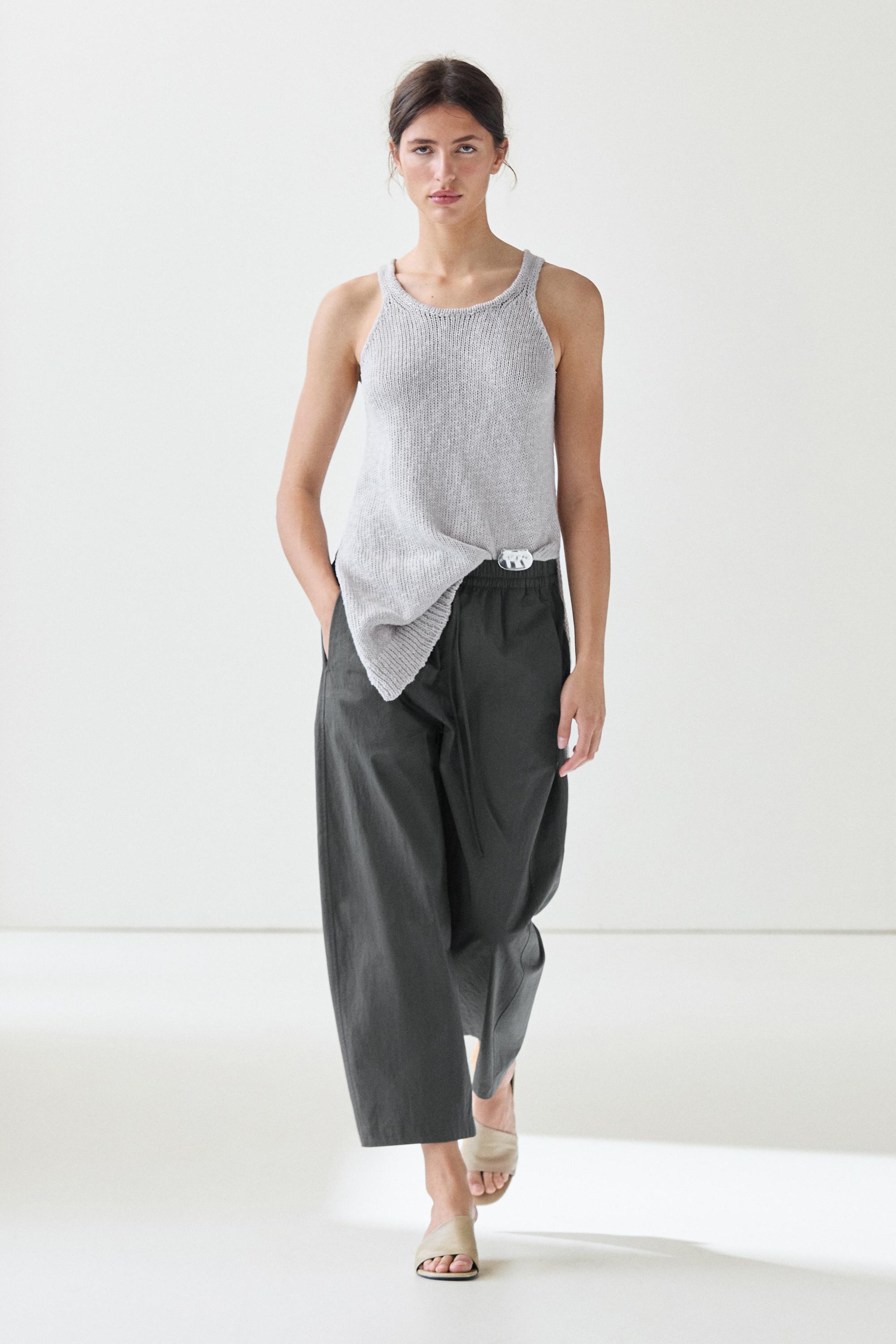 Conjunto de pantalón azul barrel cropped con cintura elástica y bolsillos laterales, y top gris sin mangas.