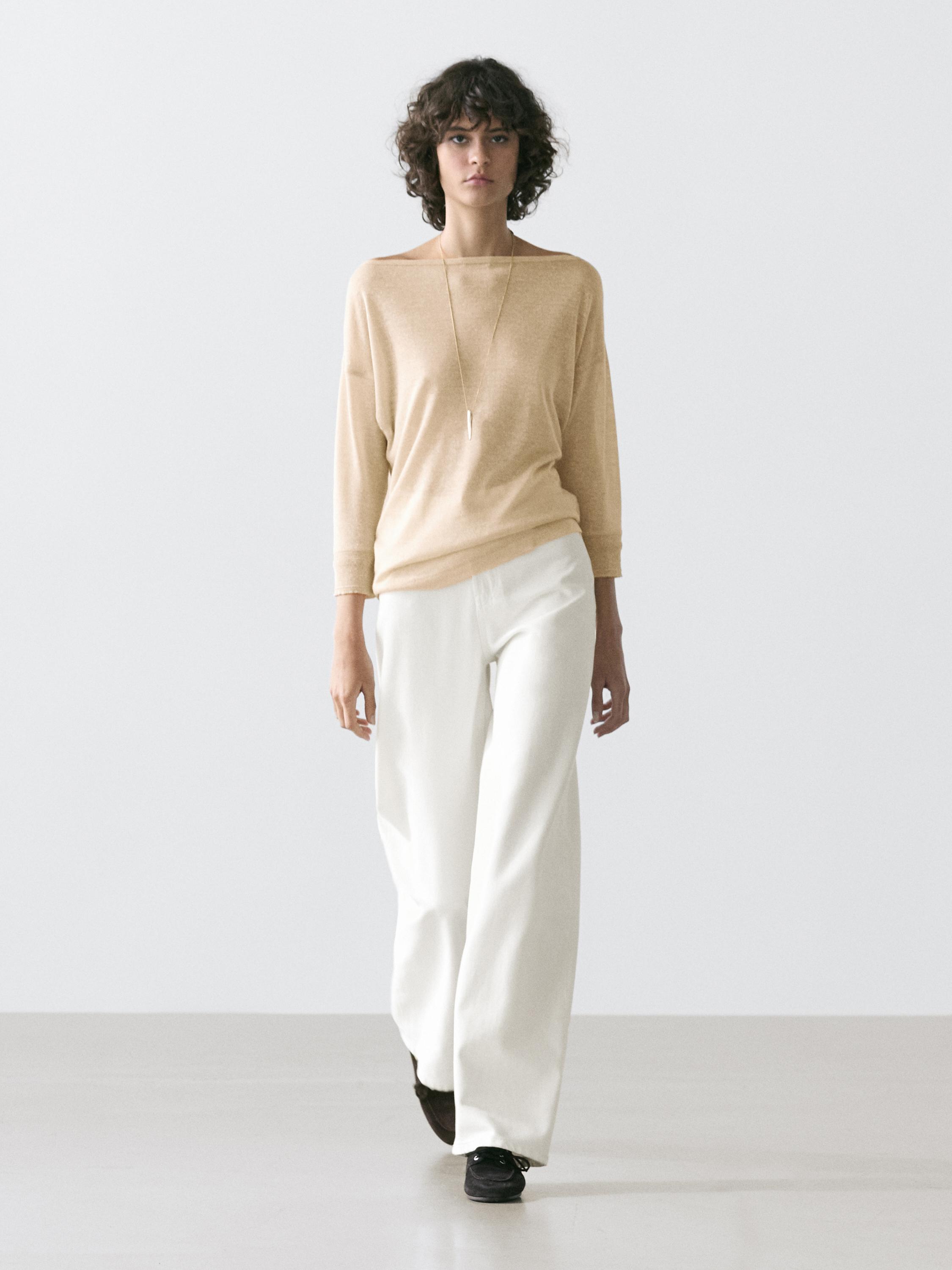 Conjunto de camiseta beige de manga larga y pantalones blancos anchos.