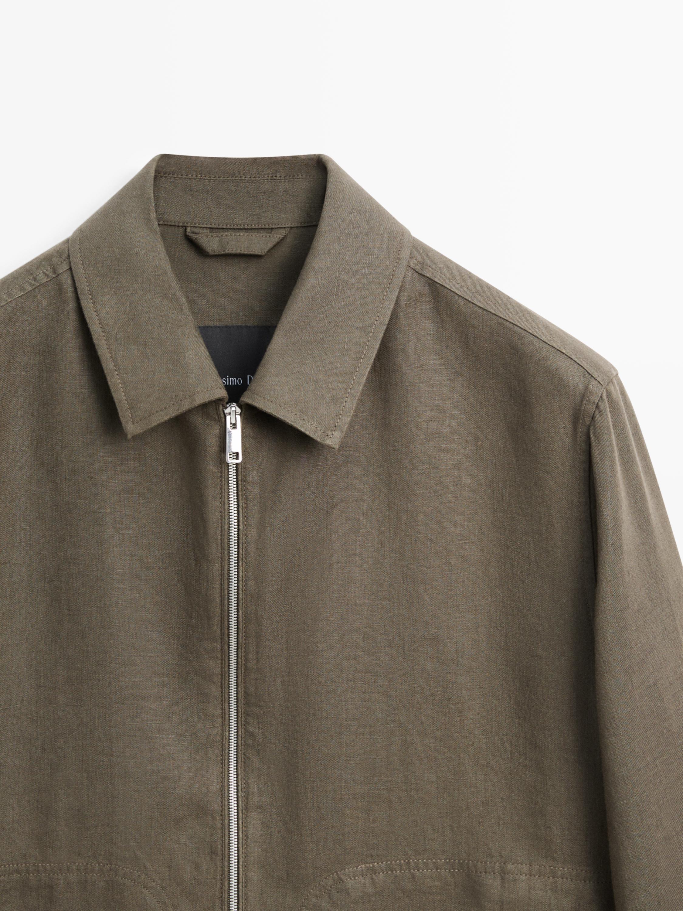 "Primeiro plano dunha chaqueta safari caqui con cremalleira frontal e colo clásico."