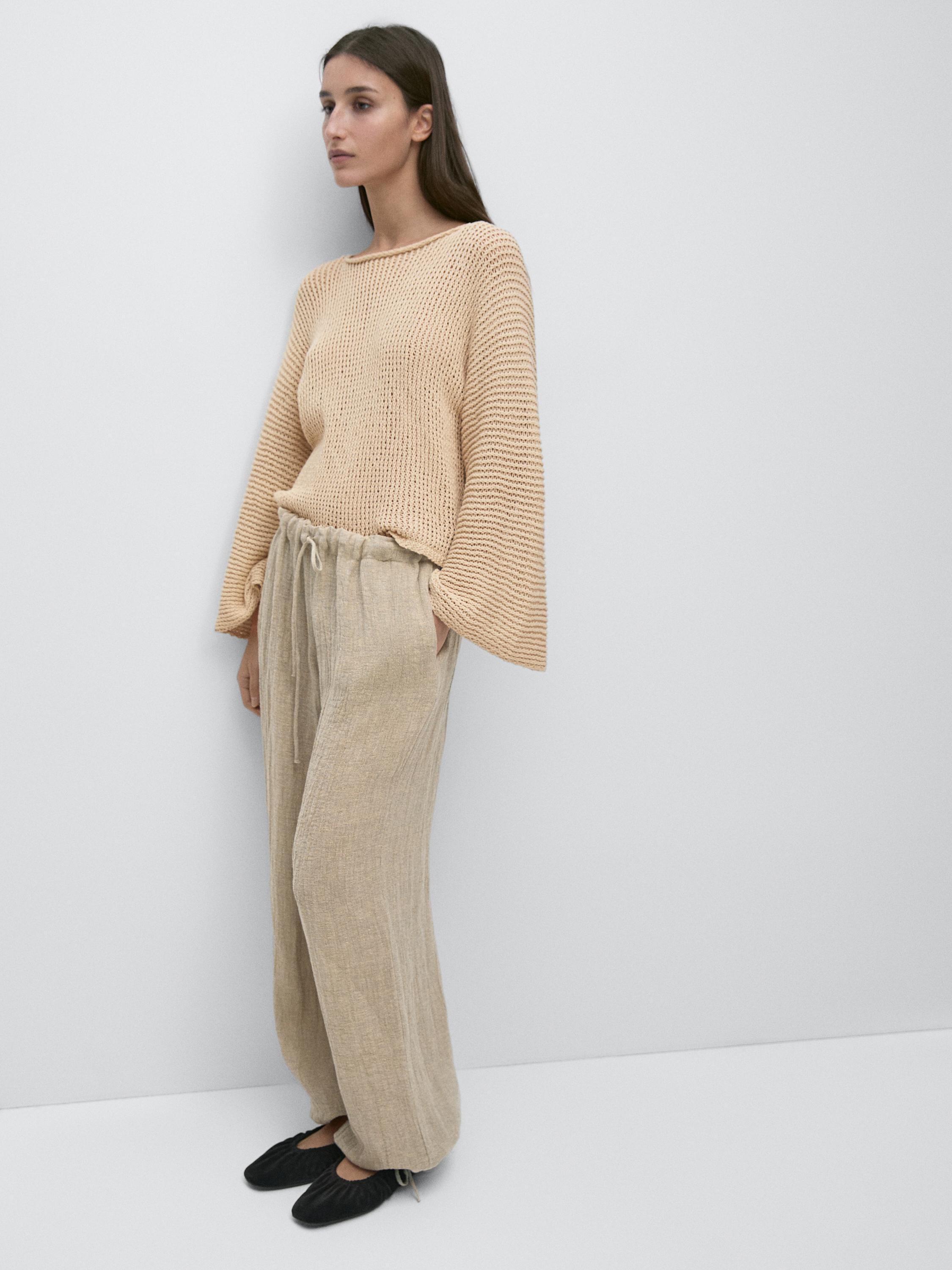 Conjunto de pantalón bombacho piedra con cintura elástica y jersey beige de punto con mangas anchas.