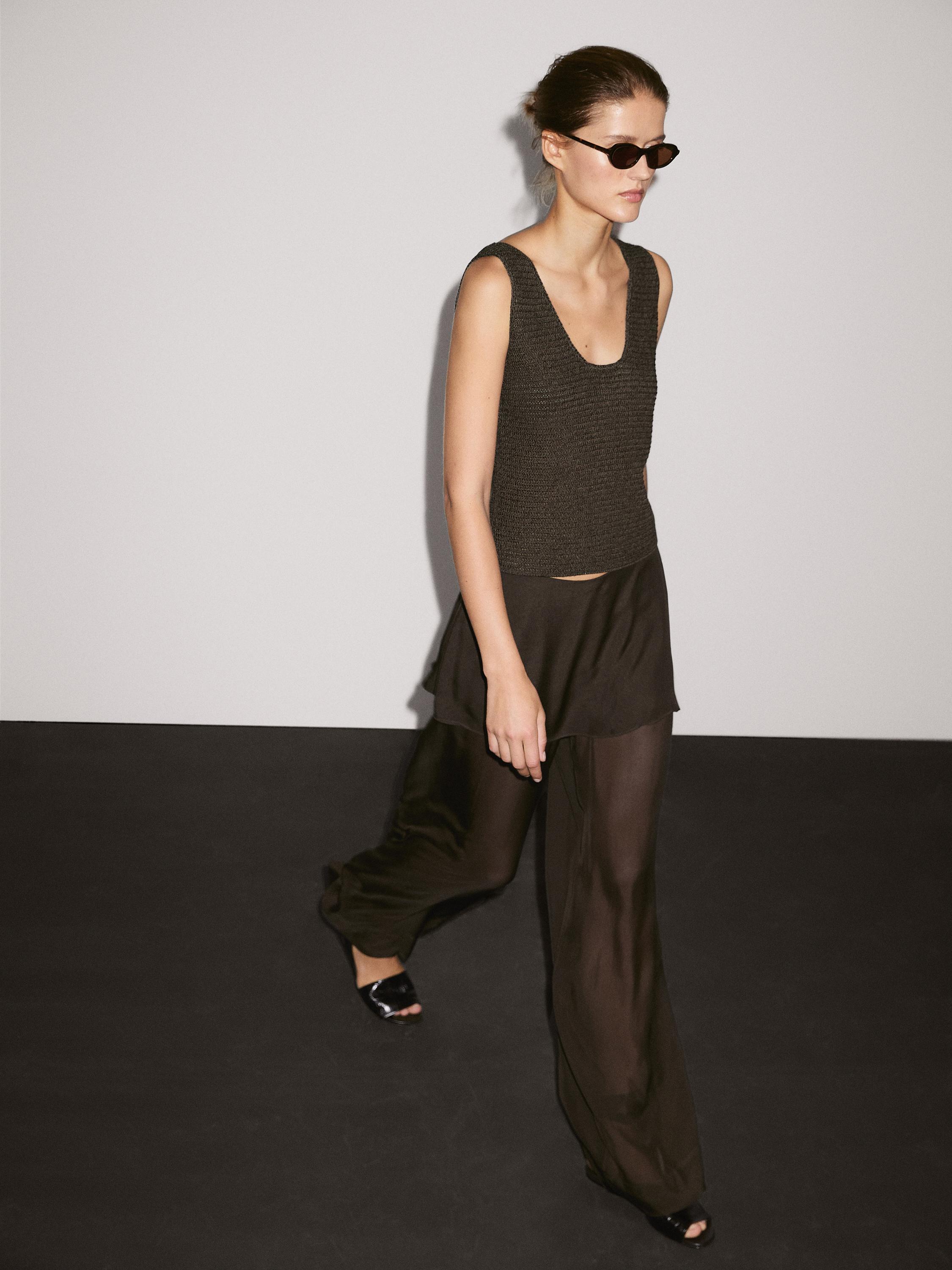 Semi-sheer flowy pants set in dark khaki and a sleeveless, round-neck top in textured fabric.