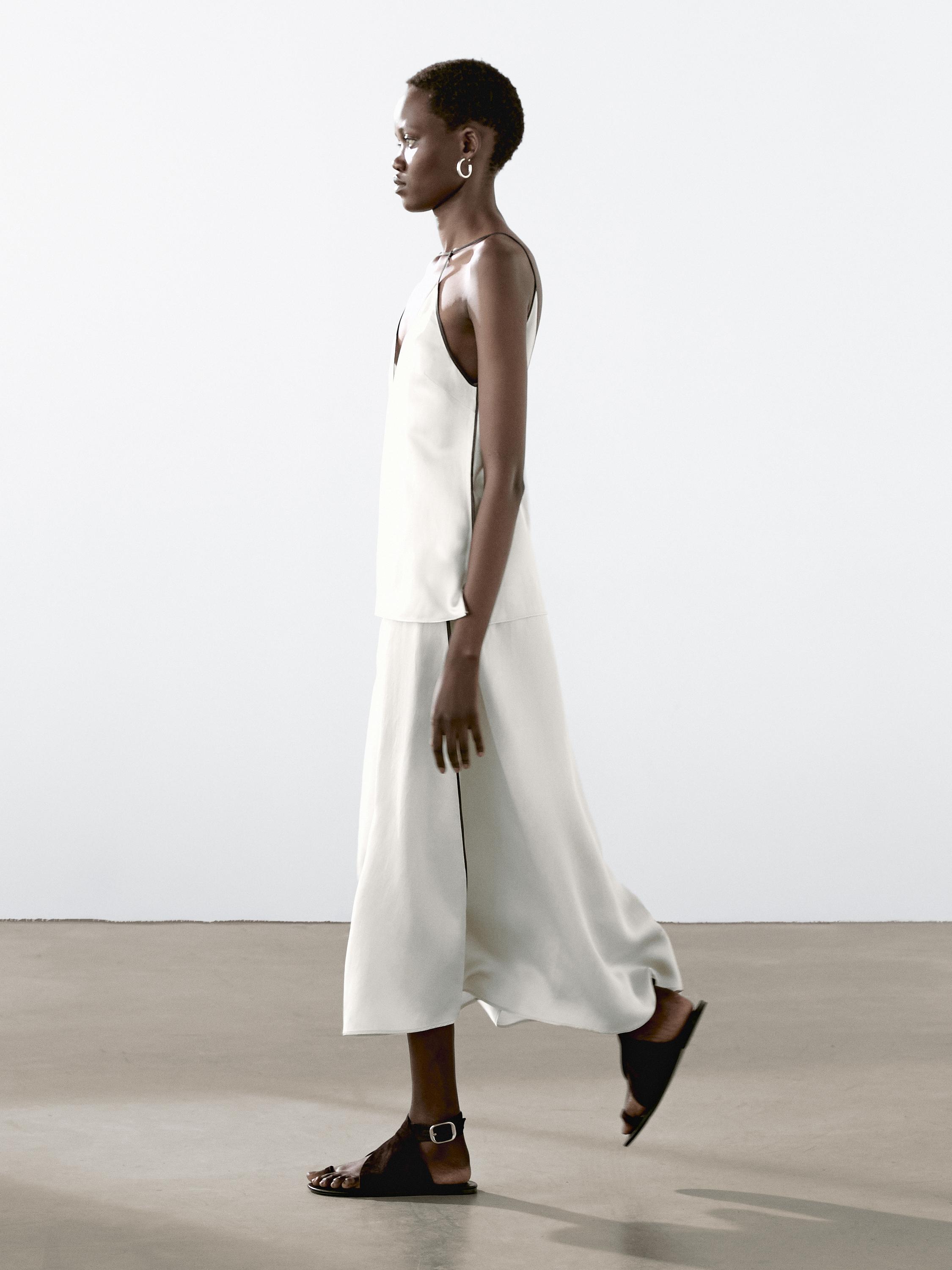 طقم من توب بدون أكمام وتنورة طويلة بيضاء، صندل أسود