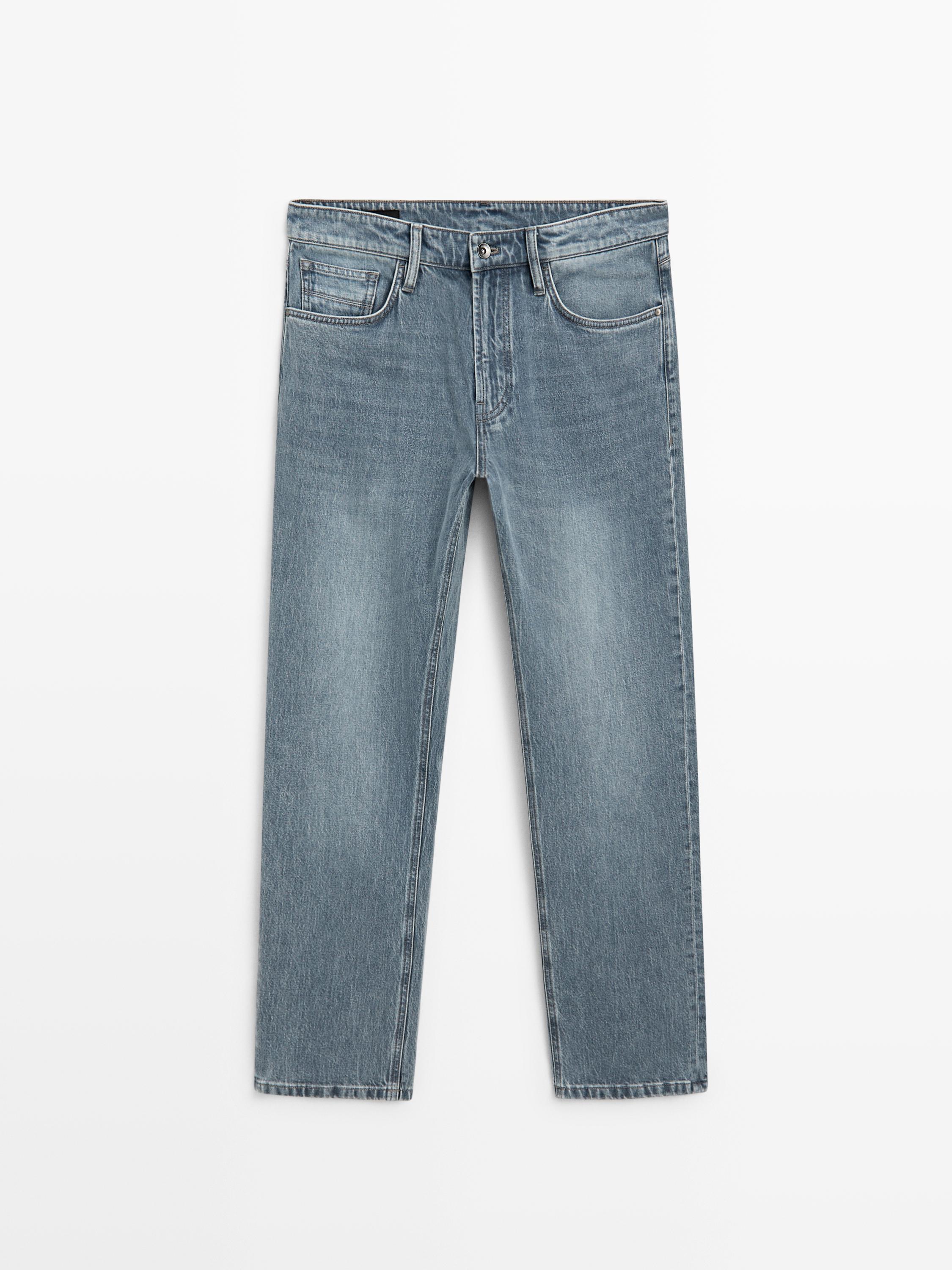 Front view of indigo tapered-cut jeans with front and back pockets.