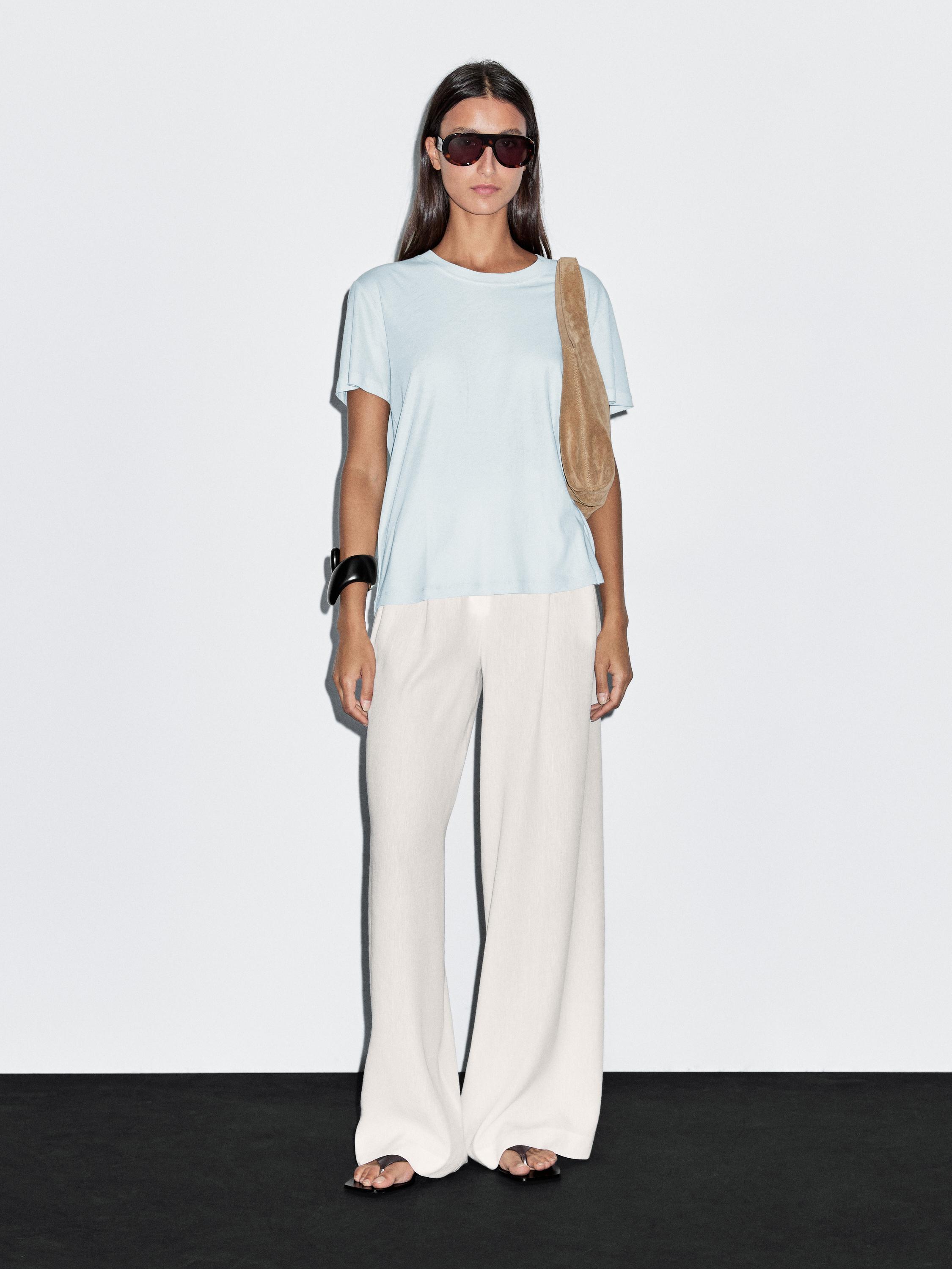 Conjunto de camiseta azul claro de manga corta y pantalones anchos blancos.