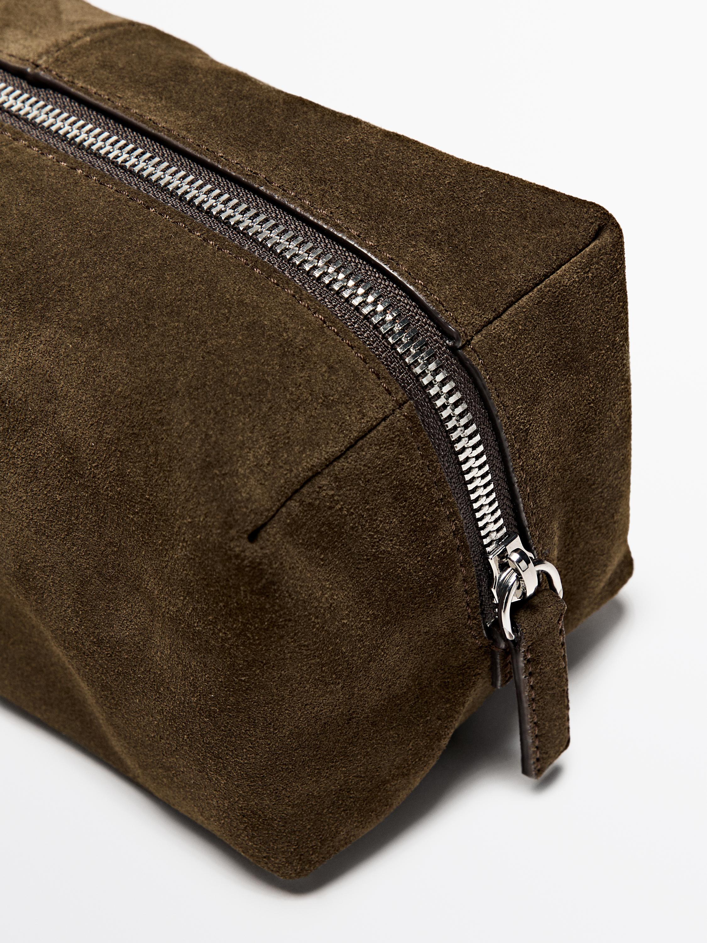 Деталь несессера цвета хаки с видимой металлической молнией сверху.