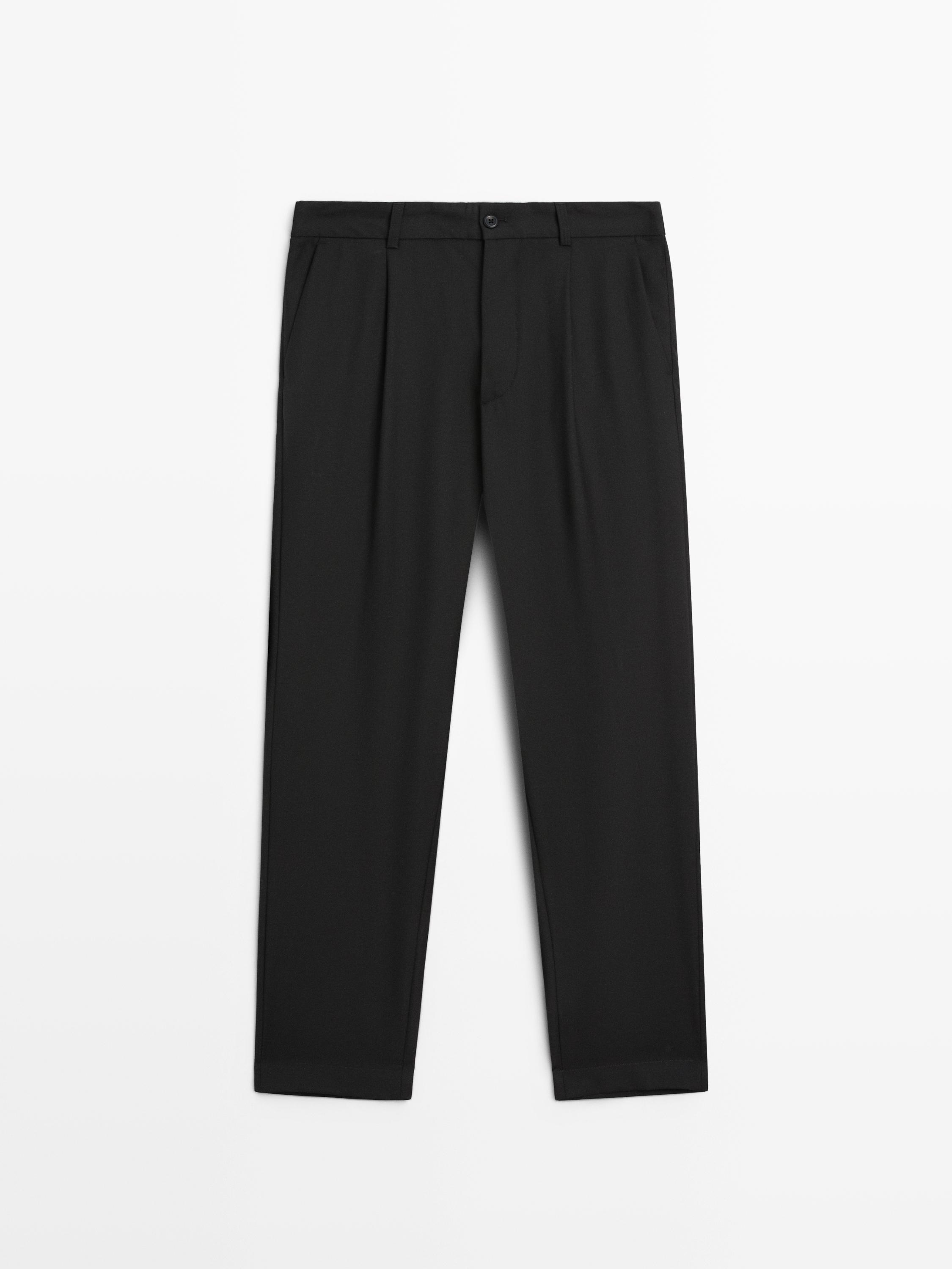 Vista frontale di pantalone nero relaxed fit con pinces e tasche laterali.