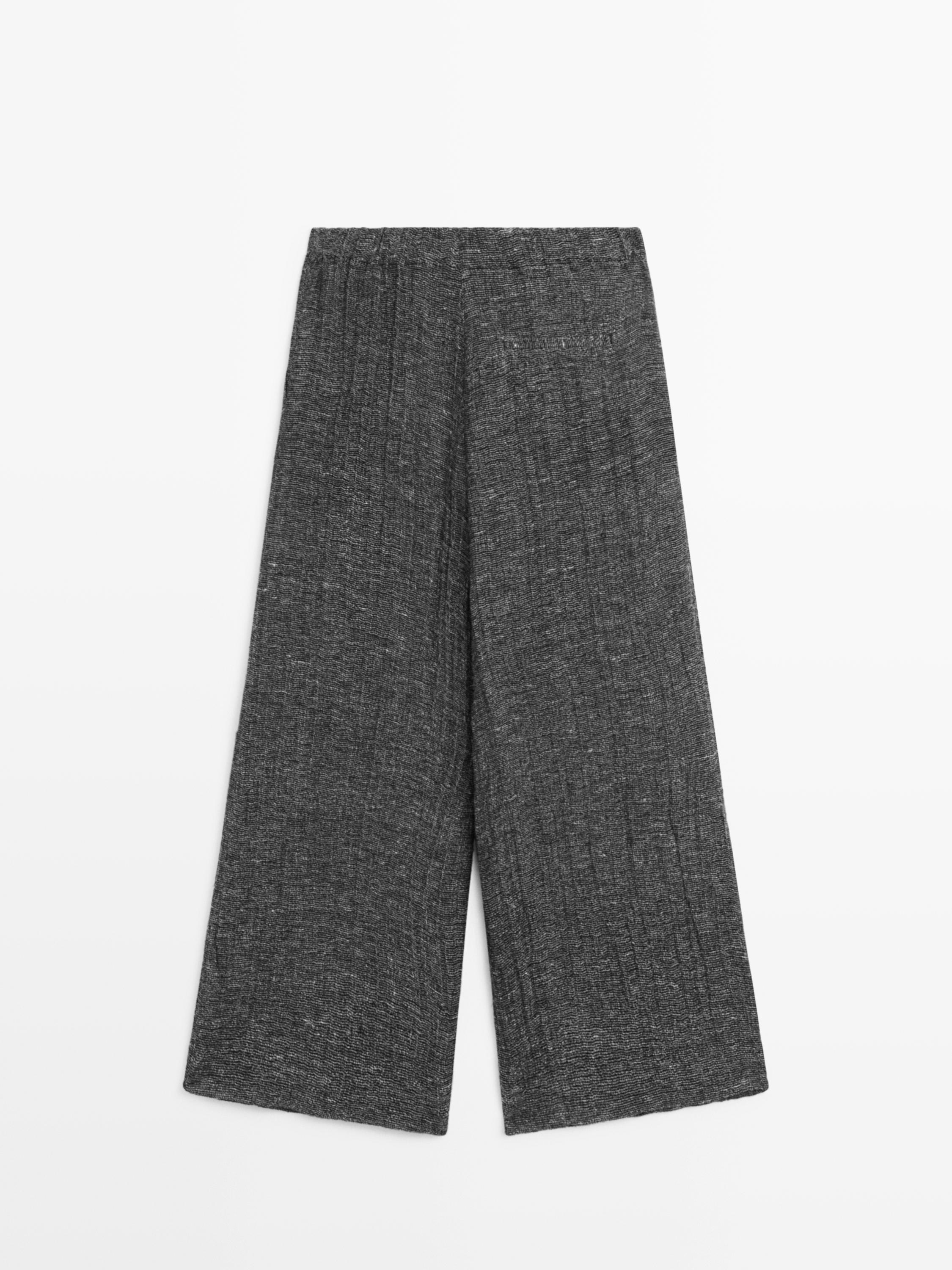 Vista frontal de pantalón gris de pierna ancha y cintura elástica.