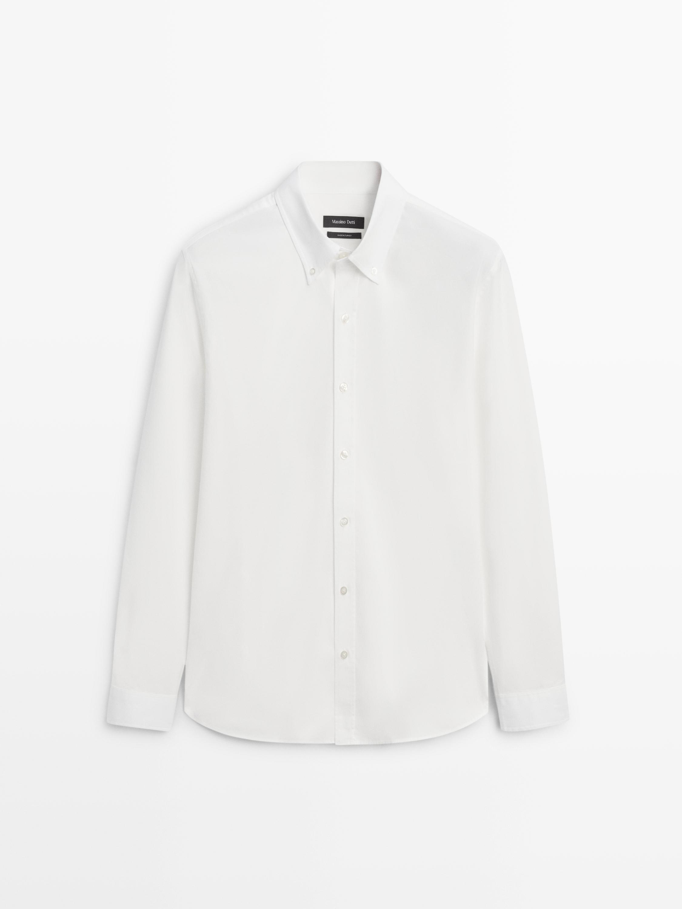 Vista frontal de camisa blanca de manga larga con cuello clásico y botonadura central.