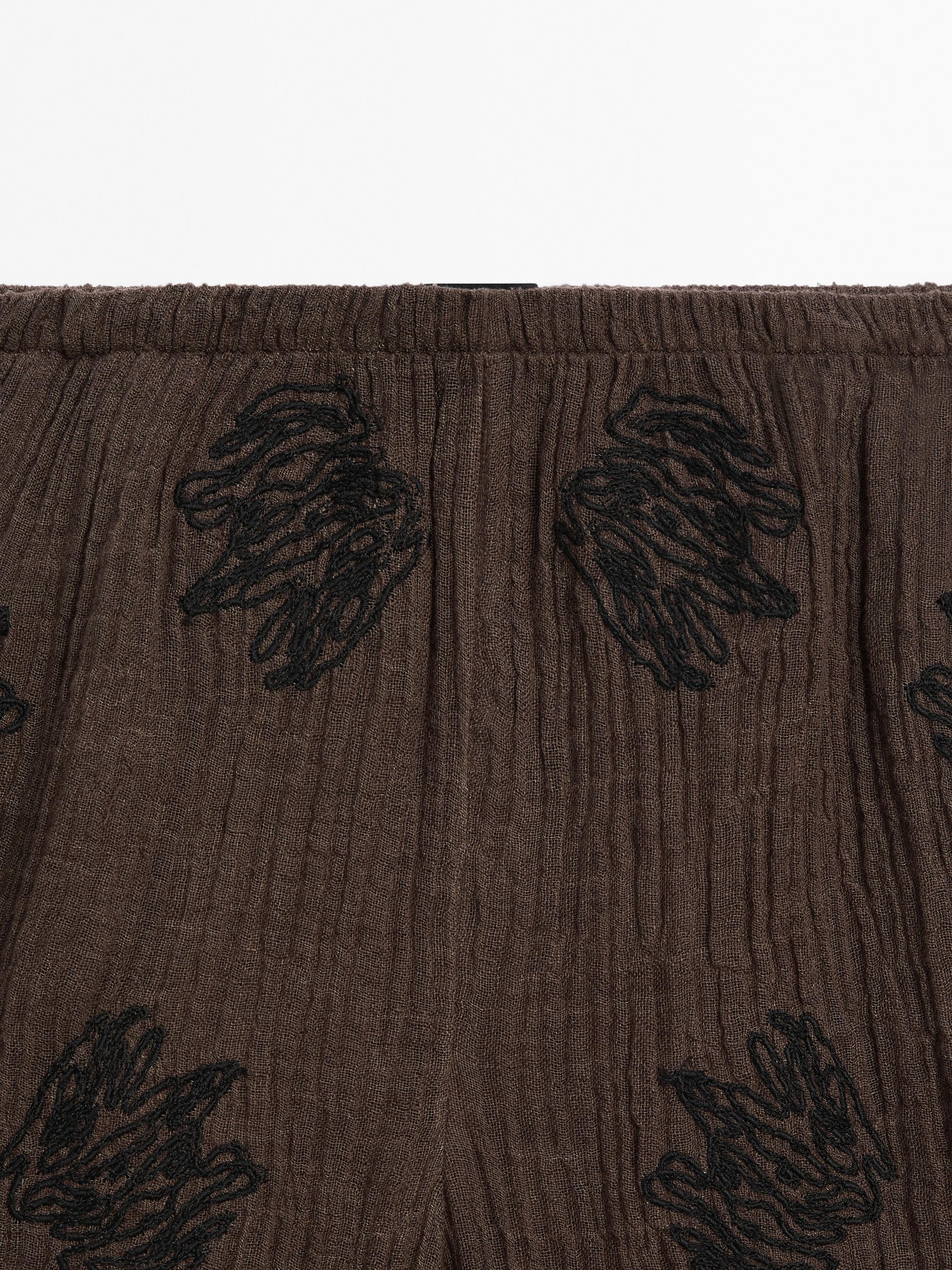 Flowing textured trousers with embroidered detail