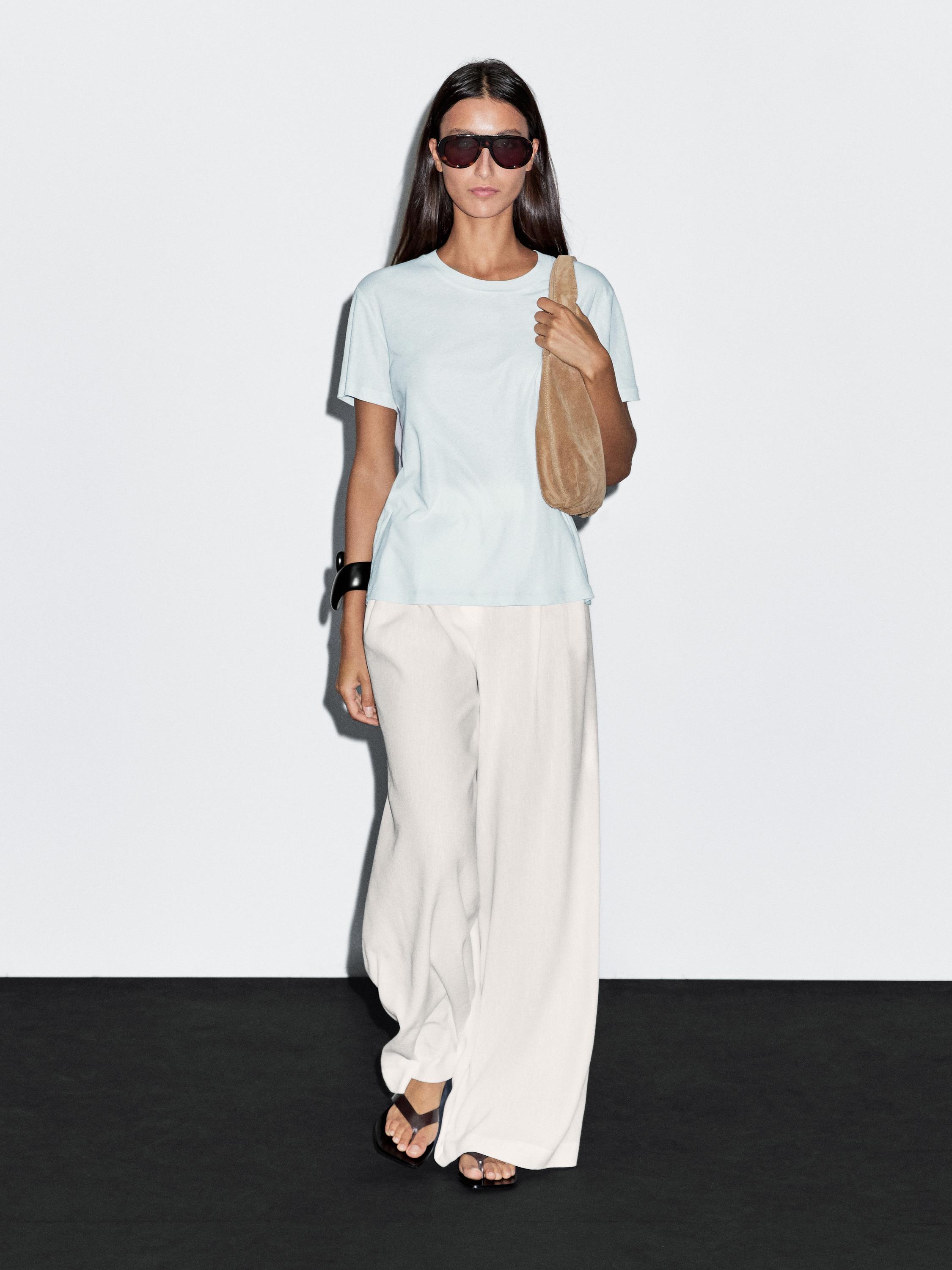 Conjunto de camiseta blanca de manga corta y pantalones anchos blancos.