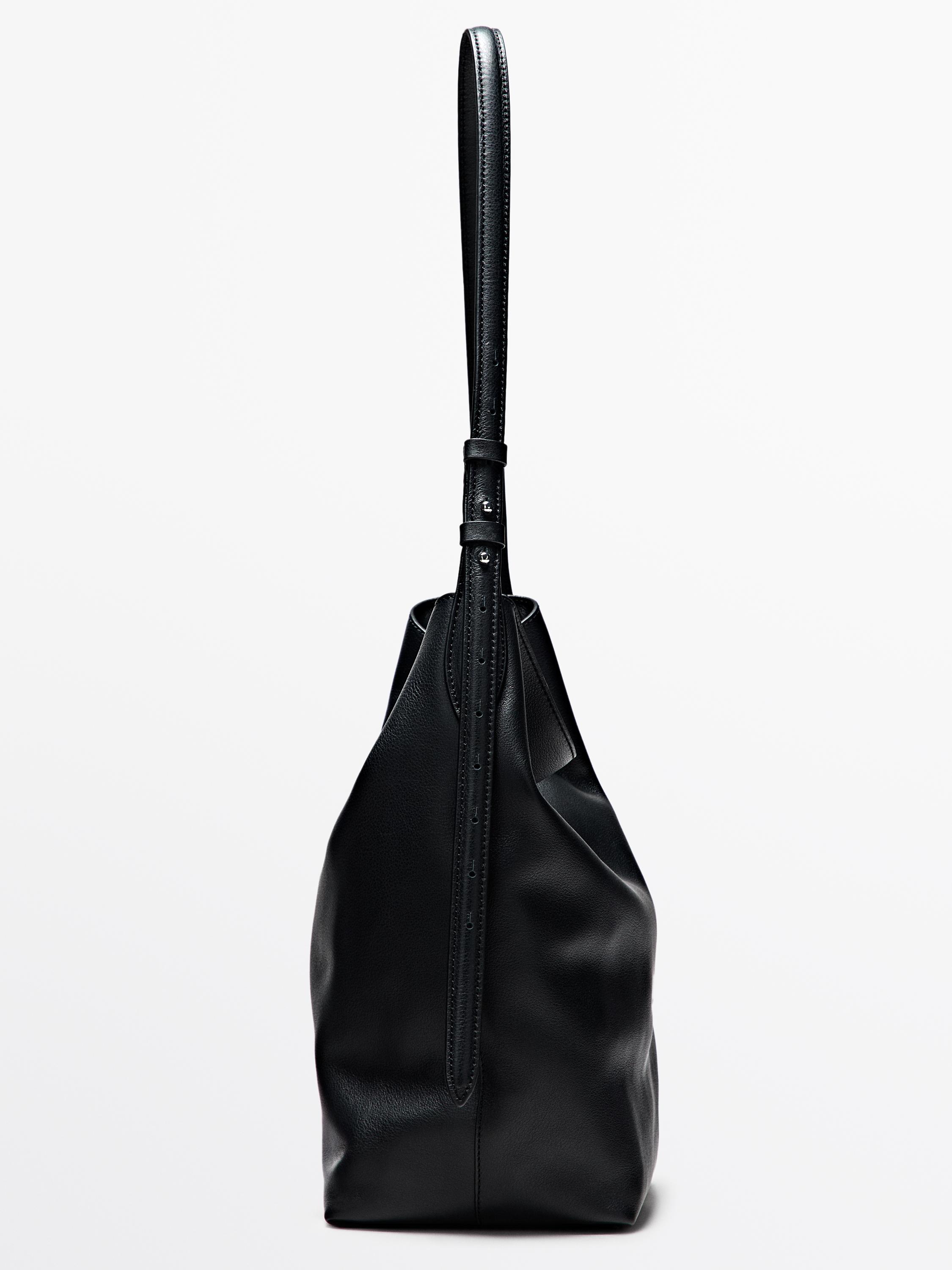 Вид сбоку черной сумки с длинным регулируемым ремнем и минималистичным дизайном.