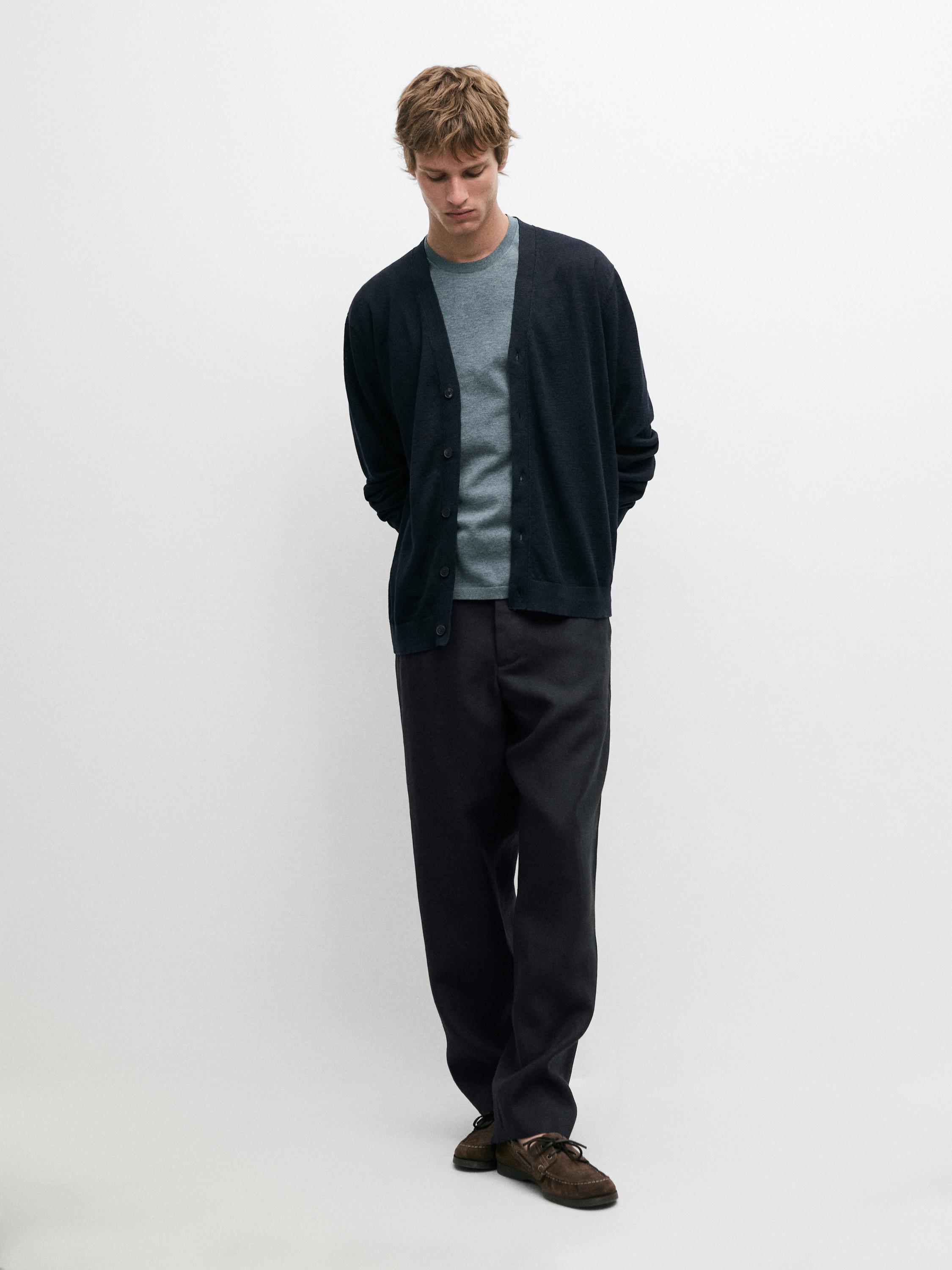 Conjunto de cárdigan azul marino con botones, camiseta gris y pantalones oscuros.