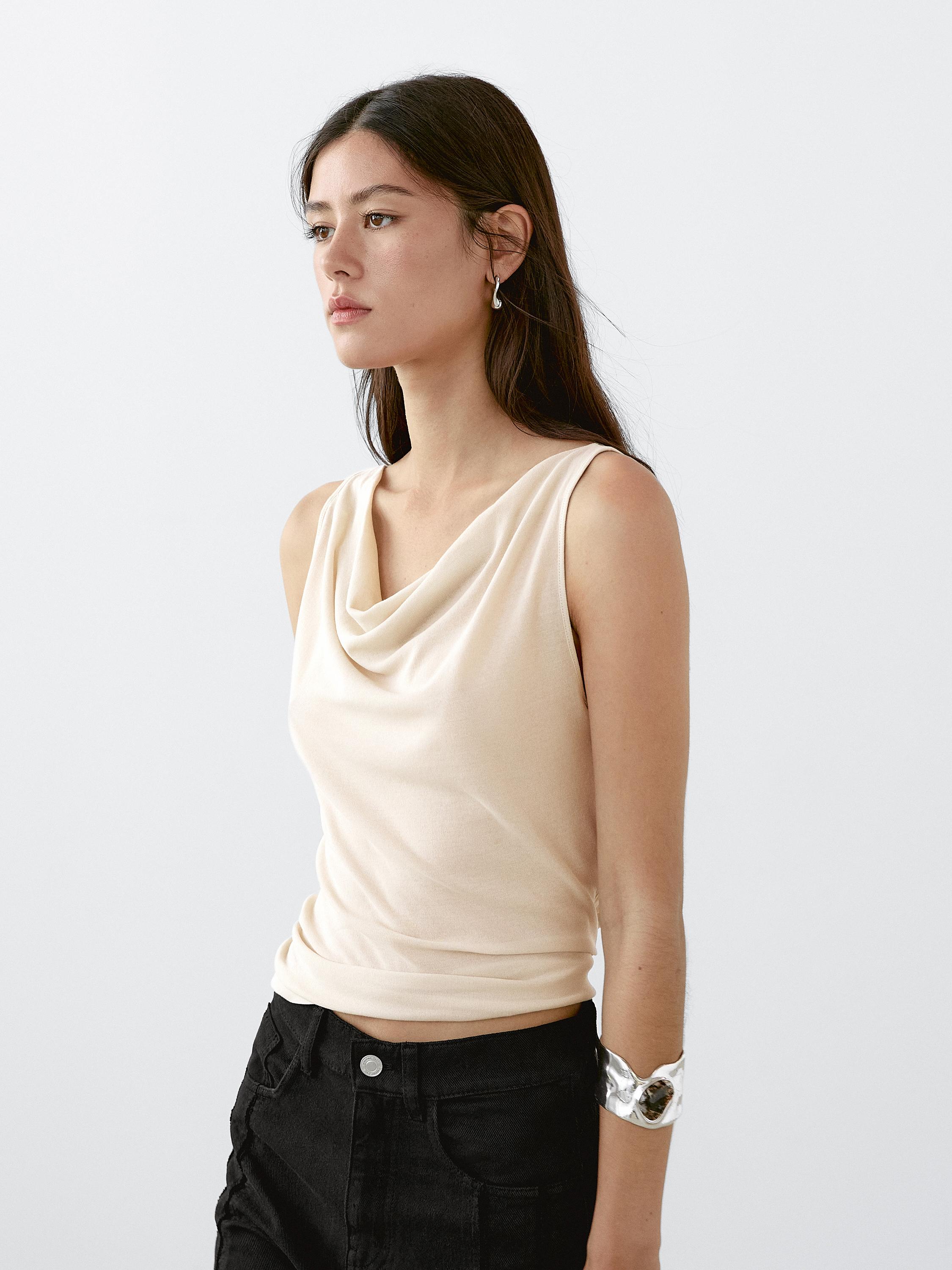 Ensemble composé d'un top beige sans manches à col drapé et d'un pantalon noir