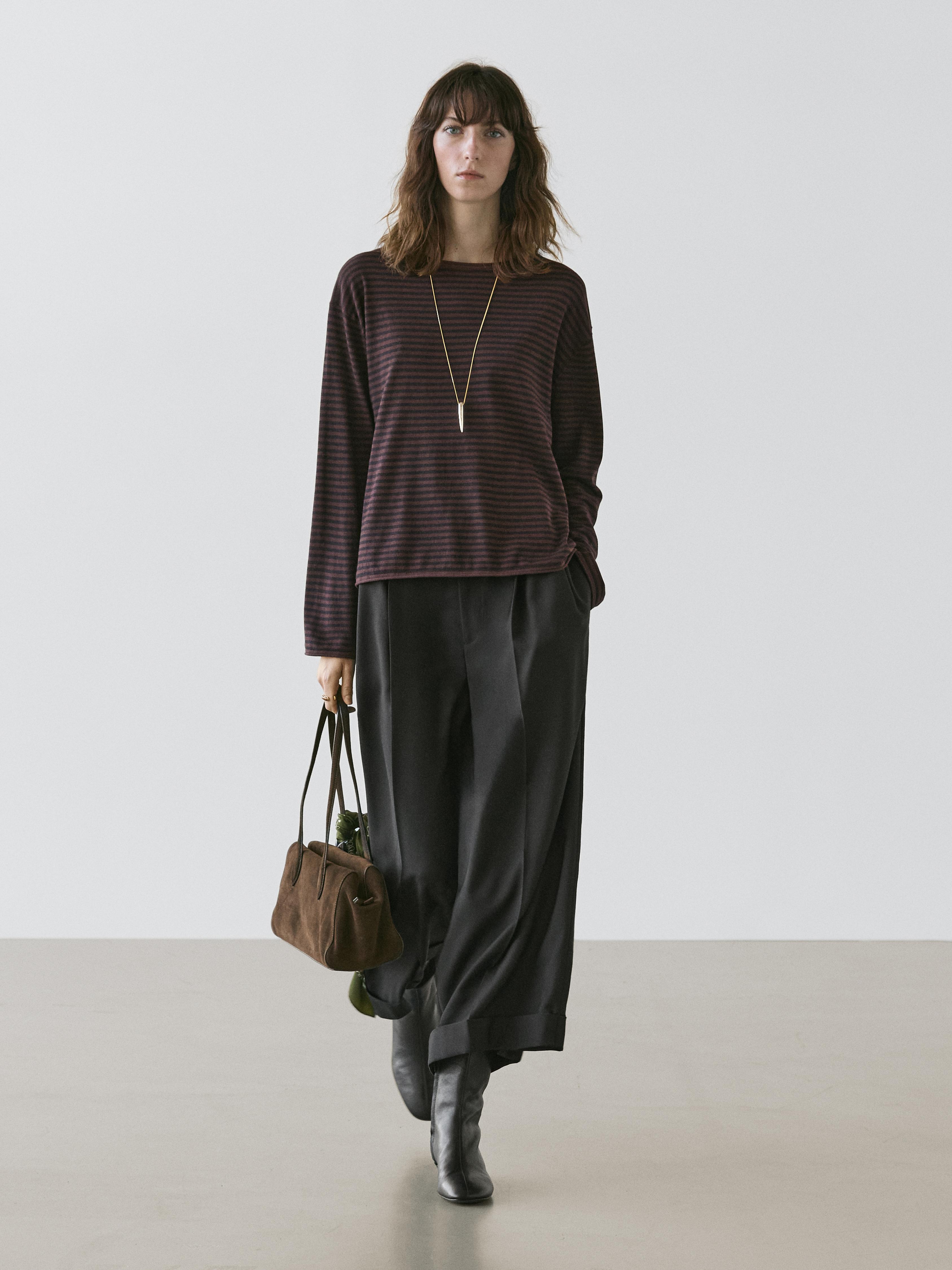 Brown striped sweater and wide black pants set, with a brown bag and black boots.