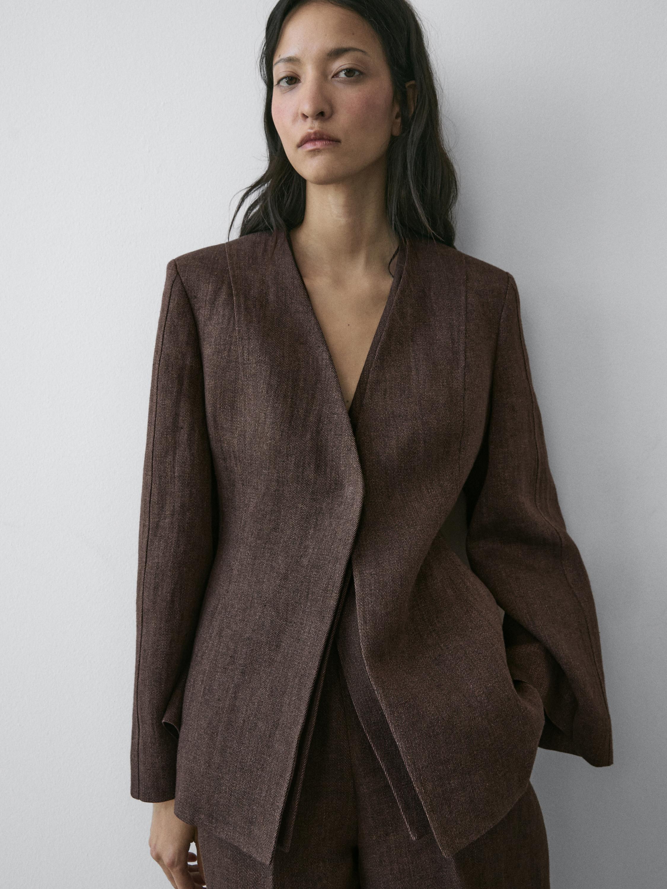 Medium shot of a brown blazer without lapels, straight cut, with side pockets.