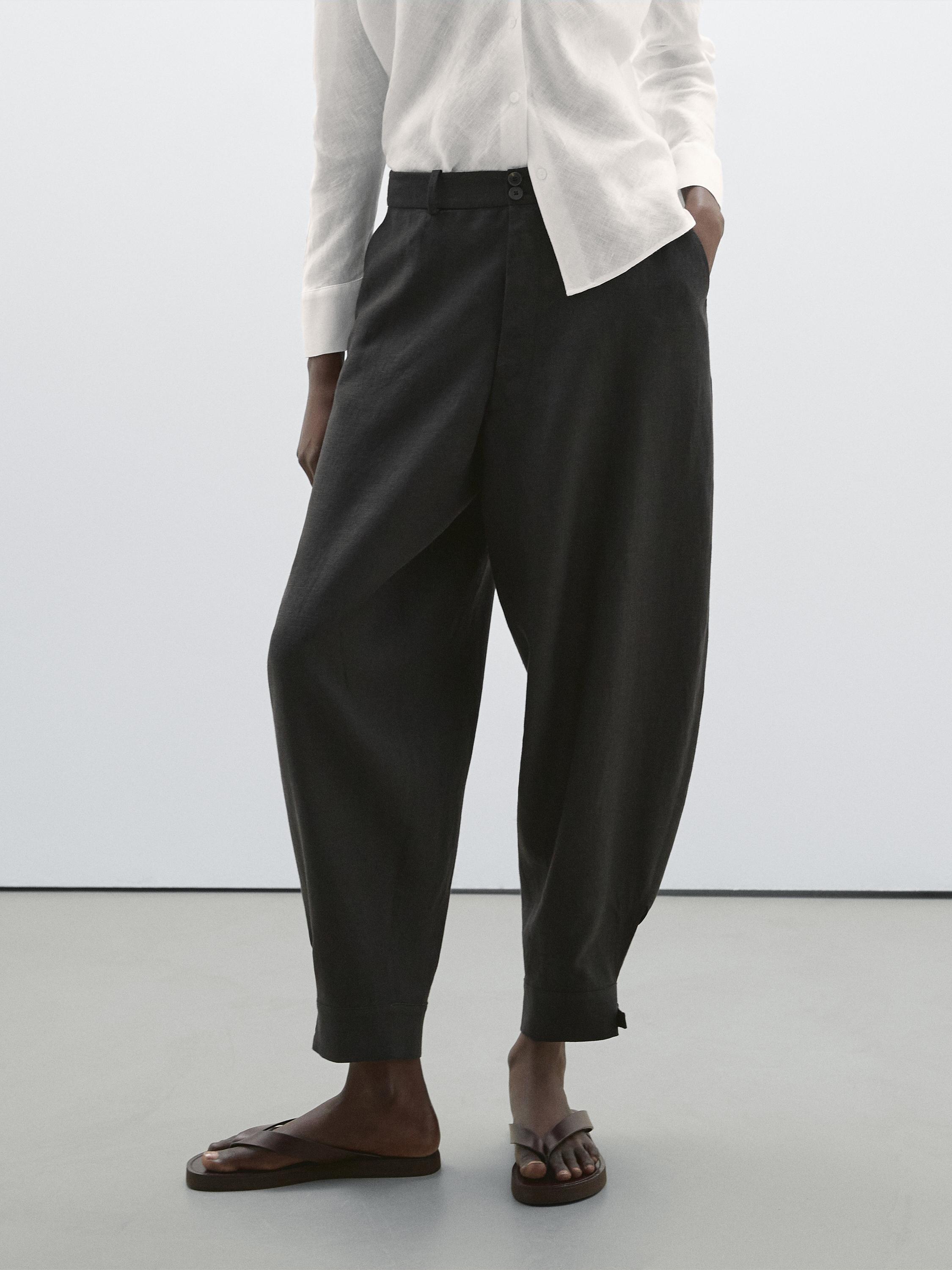 طقم مكون من قميص أبيض وبنطلون أسود فضفاض مع صندل.