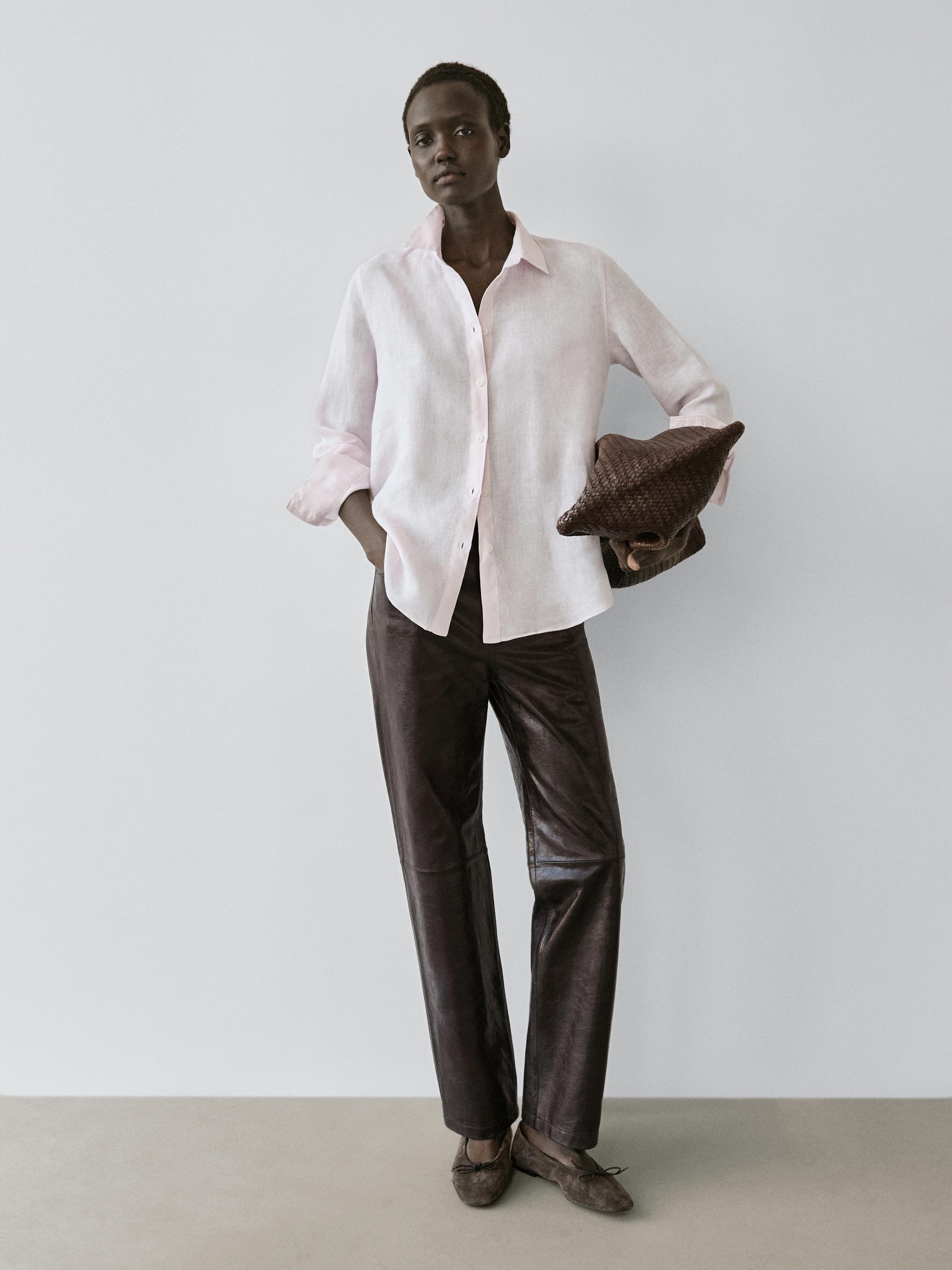 Ensemble chemise fluide rose boutonnée et pantalon marron. Poches latérales visibles sur la chemise.