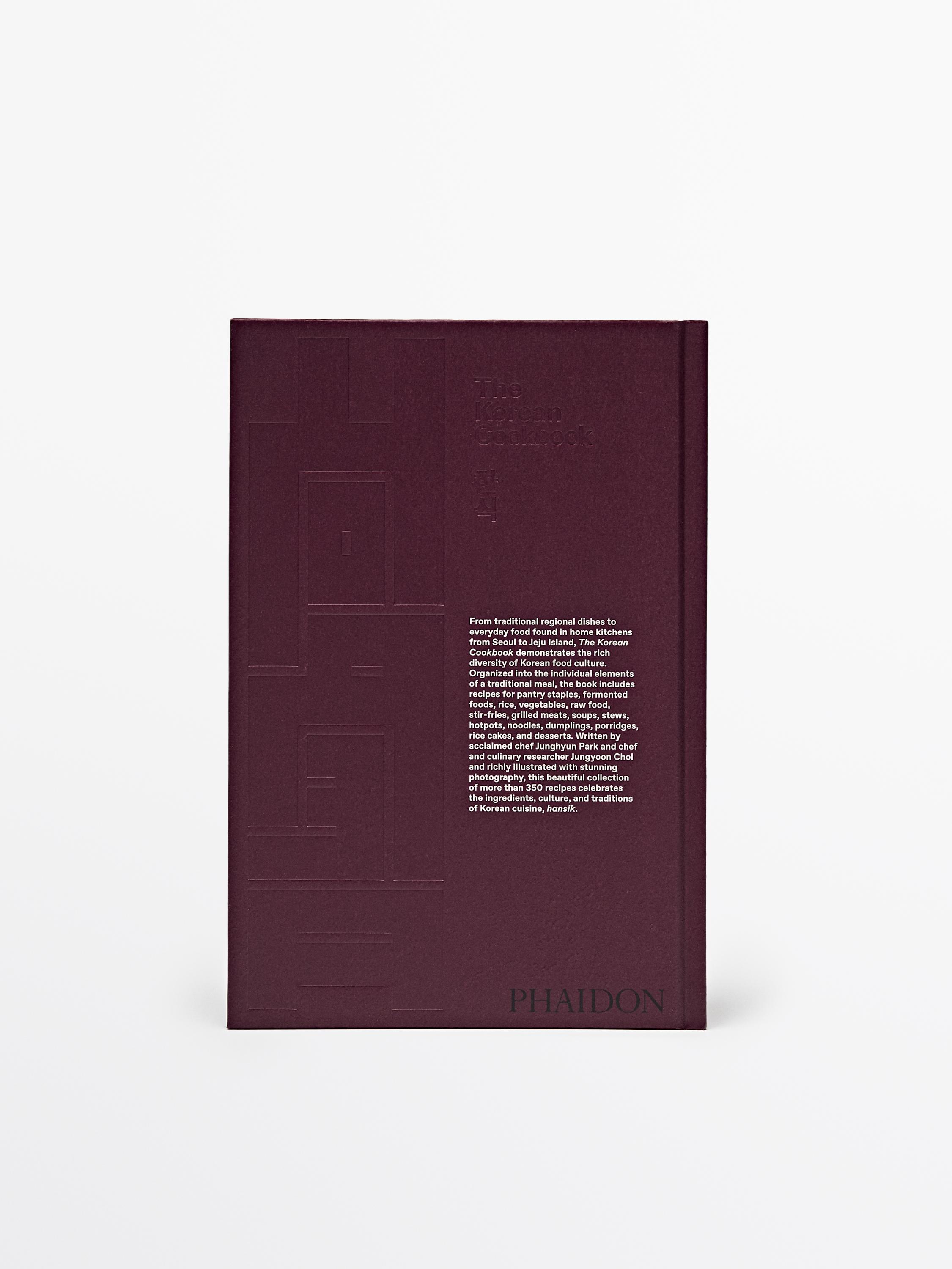 Vista frontale di un libro di cucina coreana con il testo "The Korean Cookbook", sfondo bianco.
