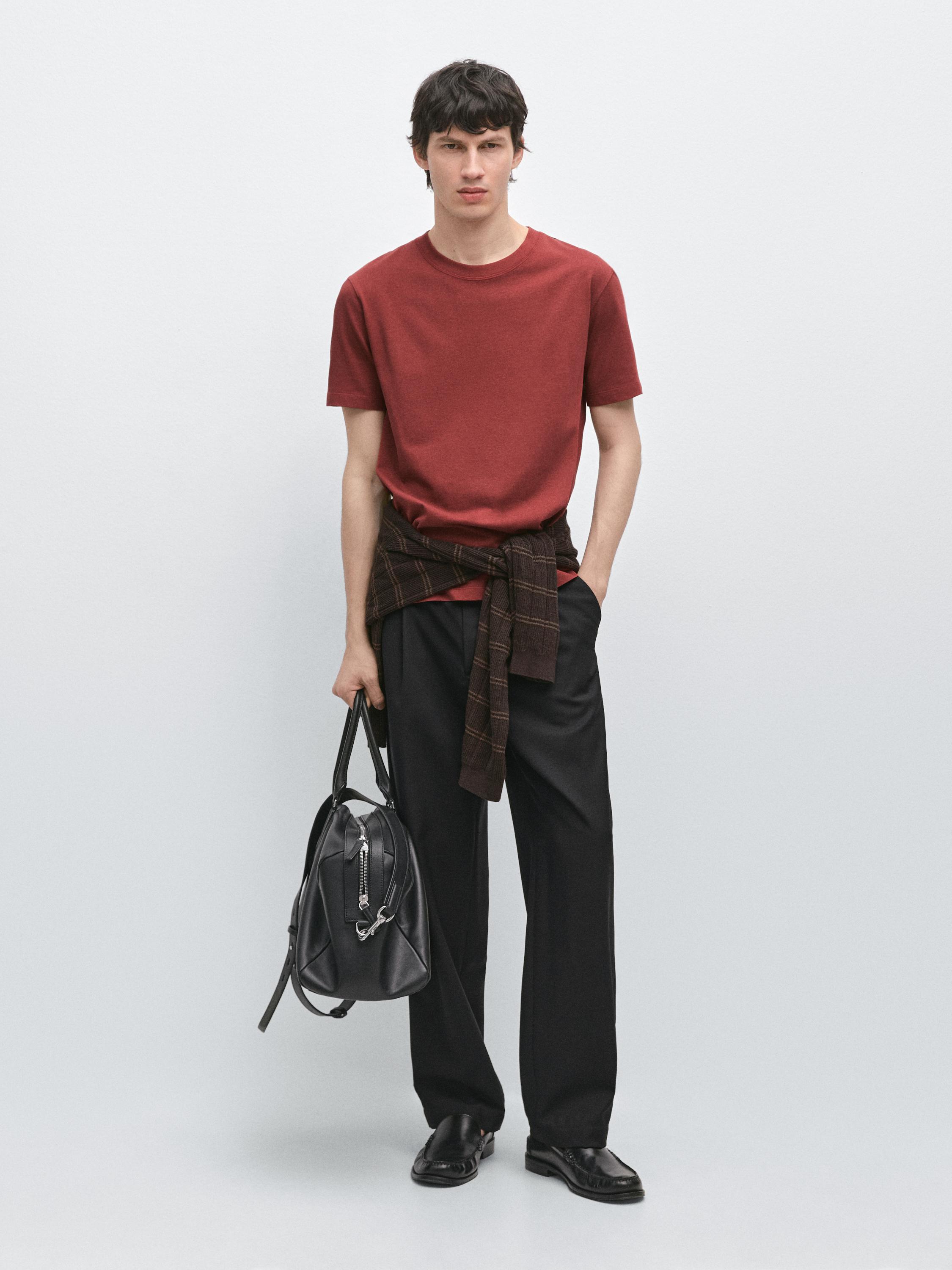 Set bestehend aus weinrotem Kurzarm-T-Shirt, schwarzer Hose, Pullover um die Taille gebunden und schwarzer Tasche.