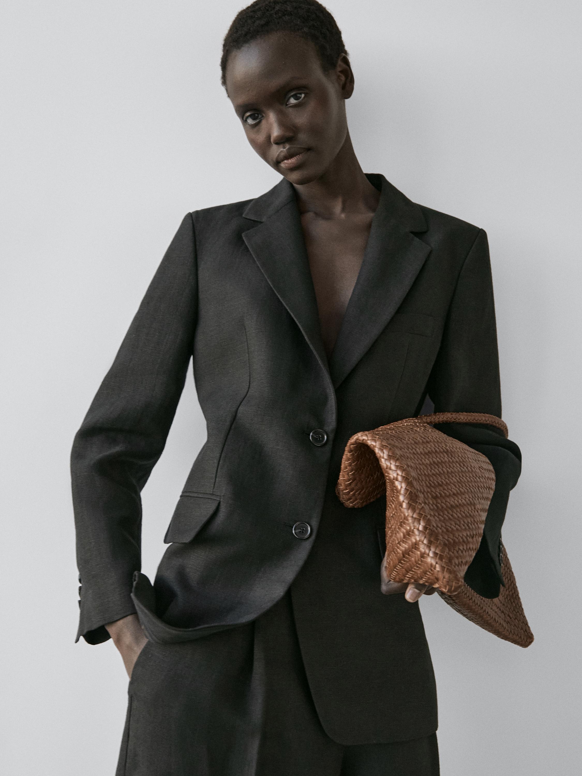 Conjunto de blazer negro con solapas y dos botones, bolsillos delanteros con solapa.