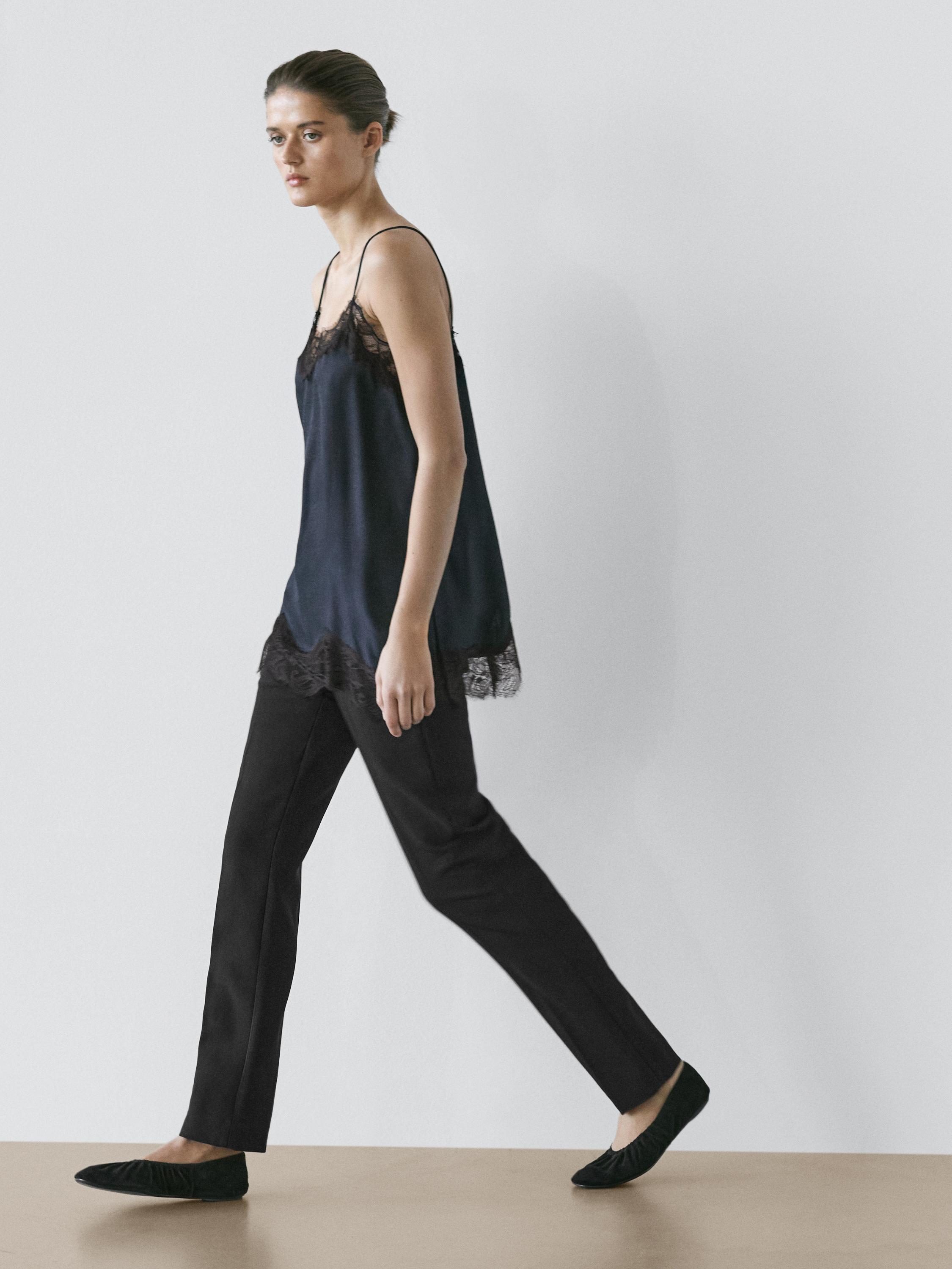 Komplet tamnoplavog čipkastog topa sa kontrastnom čipkom i crnih ravnih pantalona.